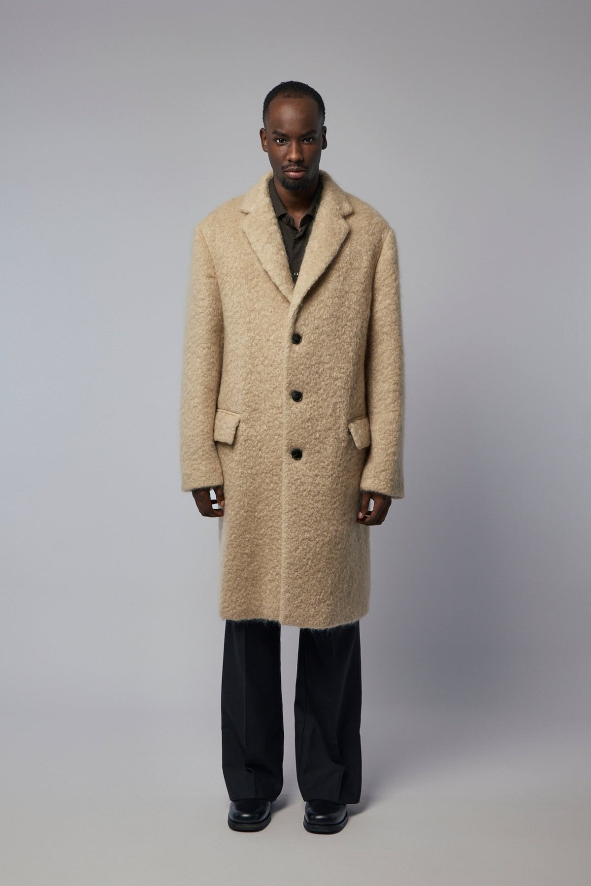 Close-up of textured cotton fabric and flap pocket detail on coat