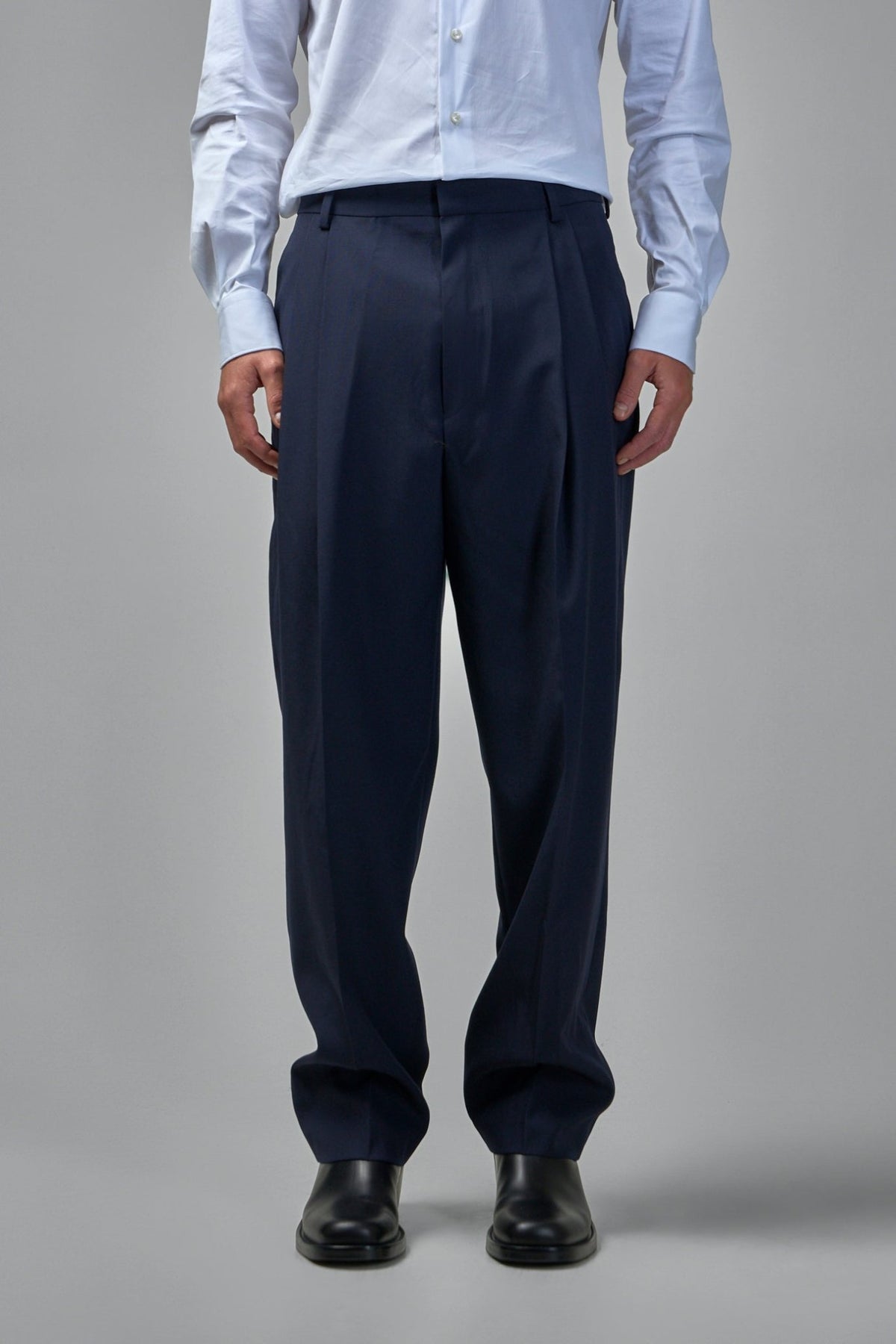Close-up of navy wool fabric texture and pressed center creases on flared pants
