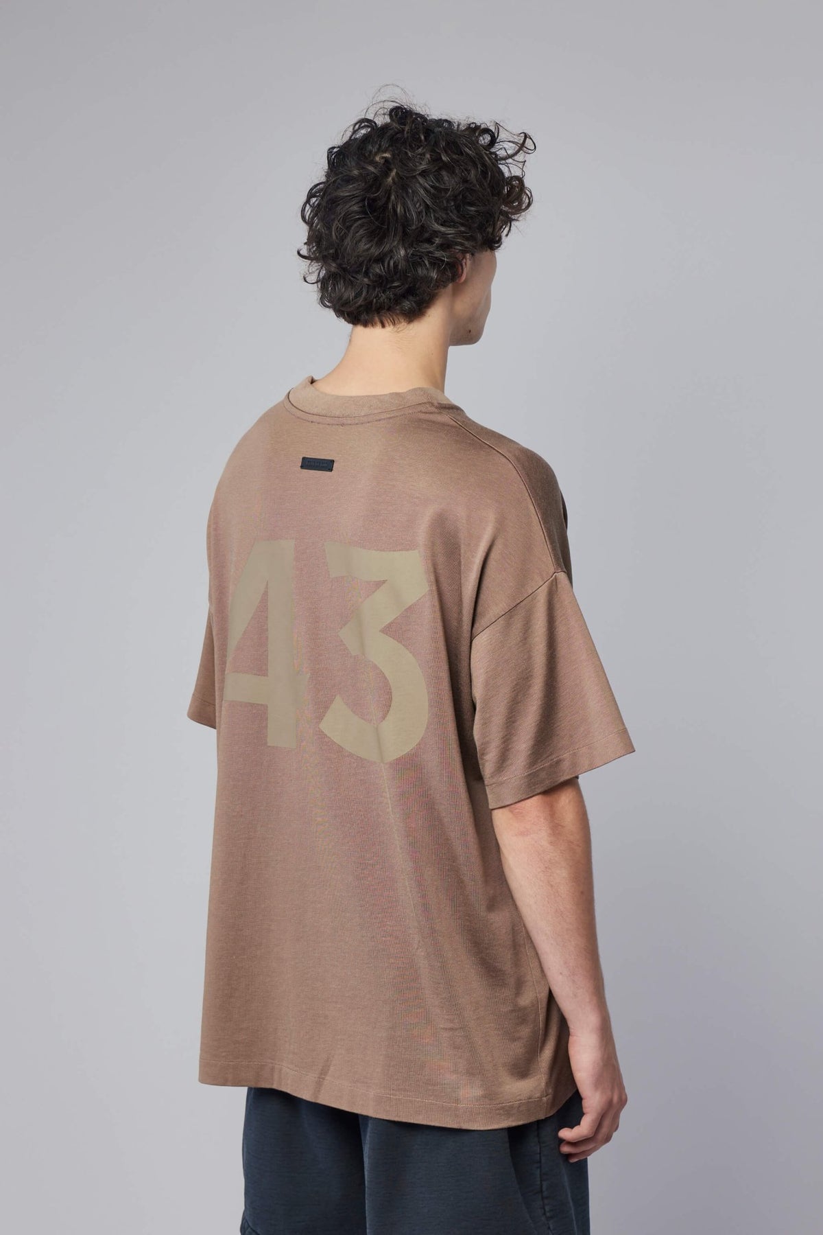 Detail shot of Fear Of God tee ribbed collar and signature branding elements, view 5