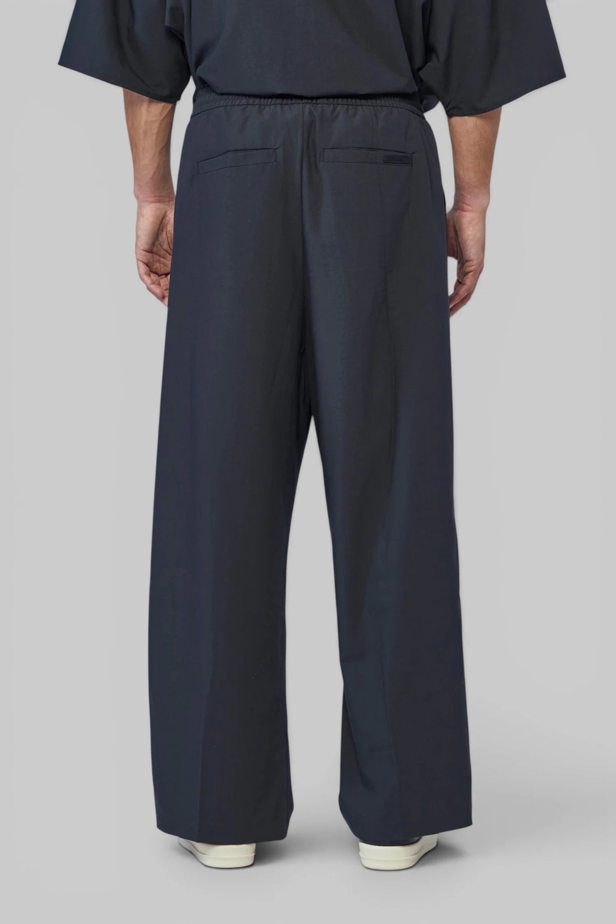 Fabric detail showing polyester-silk-wool blend on Essentials wide-leg trousers