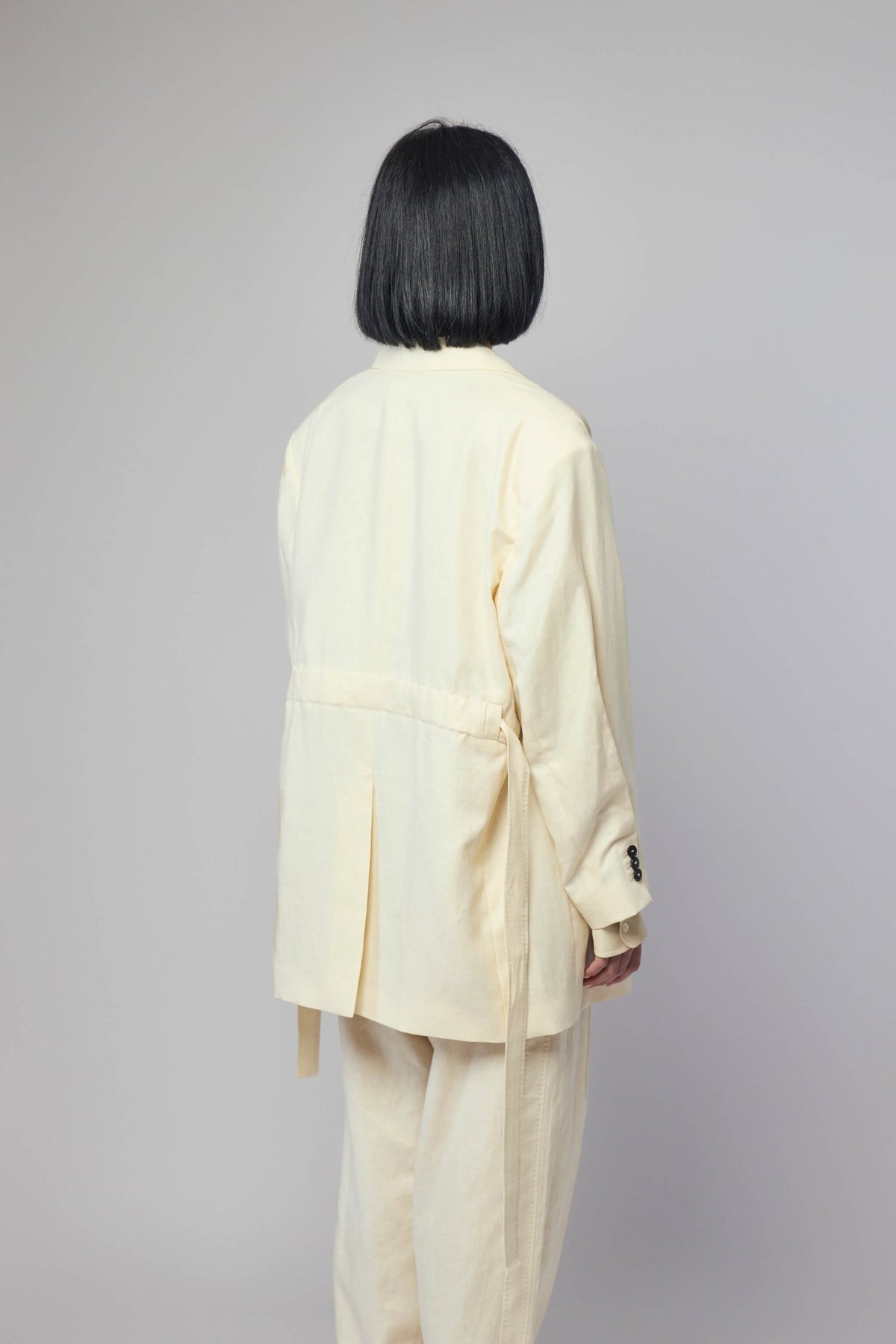 Back view of Frenken Crush Linen Wrap Blazer showcasing the elegant draping and tailoring details, view 5