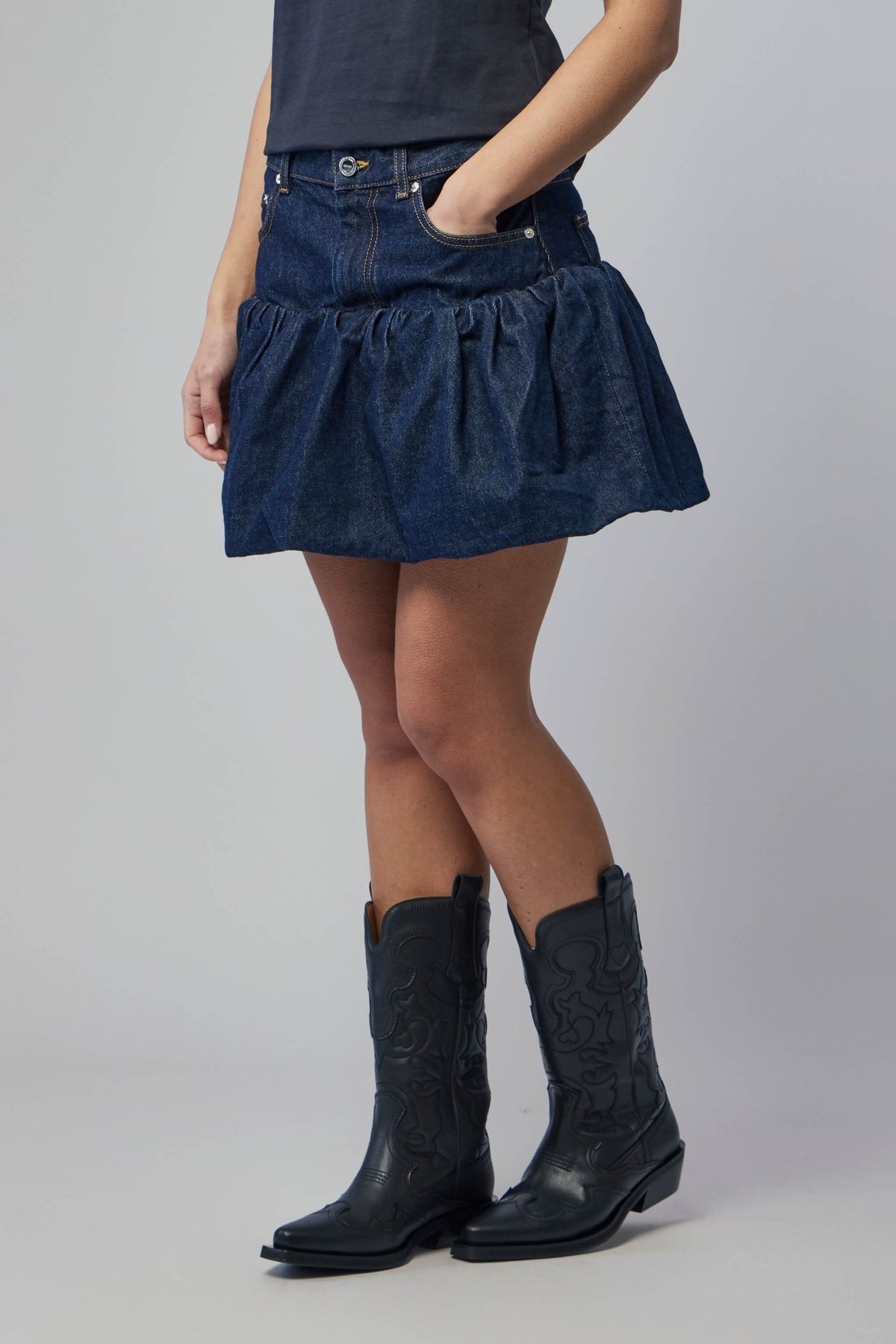 Model wearing Ganni rinse denim bubble mini skirt styled casually