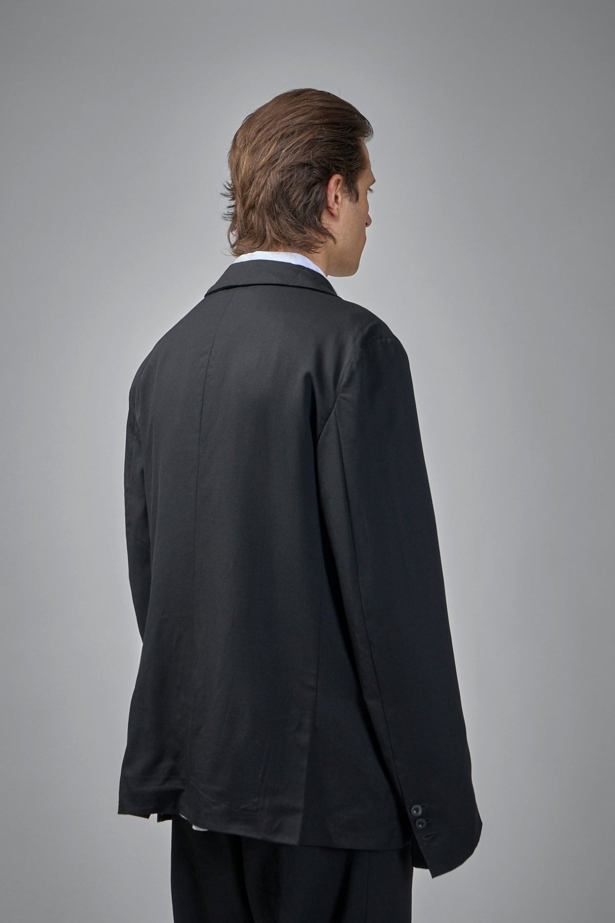 Peak lapel detail showing silk hand-stitched buttonholes and horn buttons