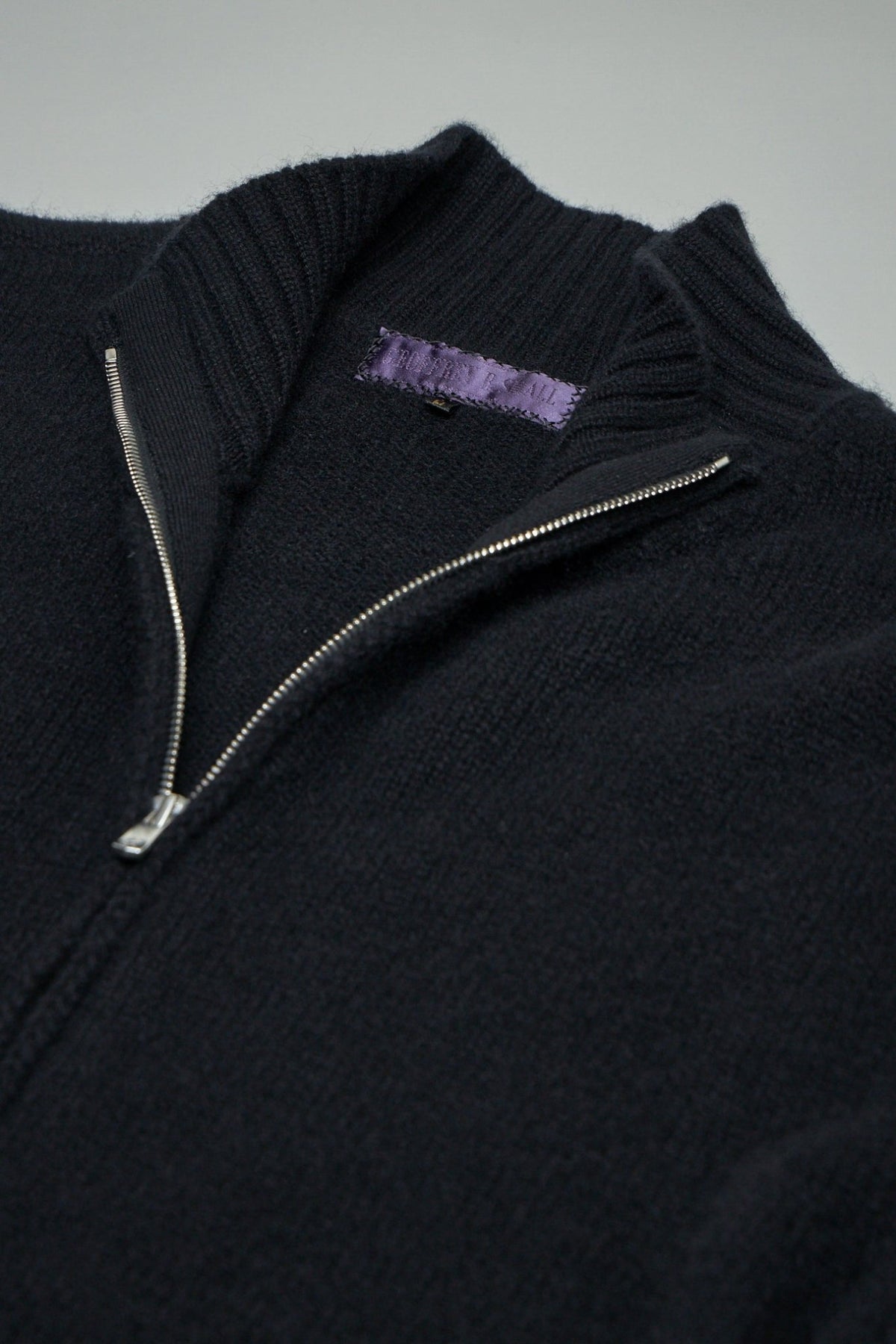 Close-up of Excella zipper and pure silk label on cashmere cardigan, view 5