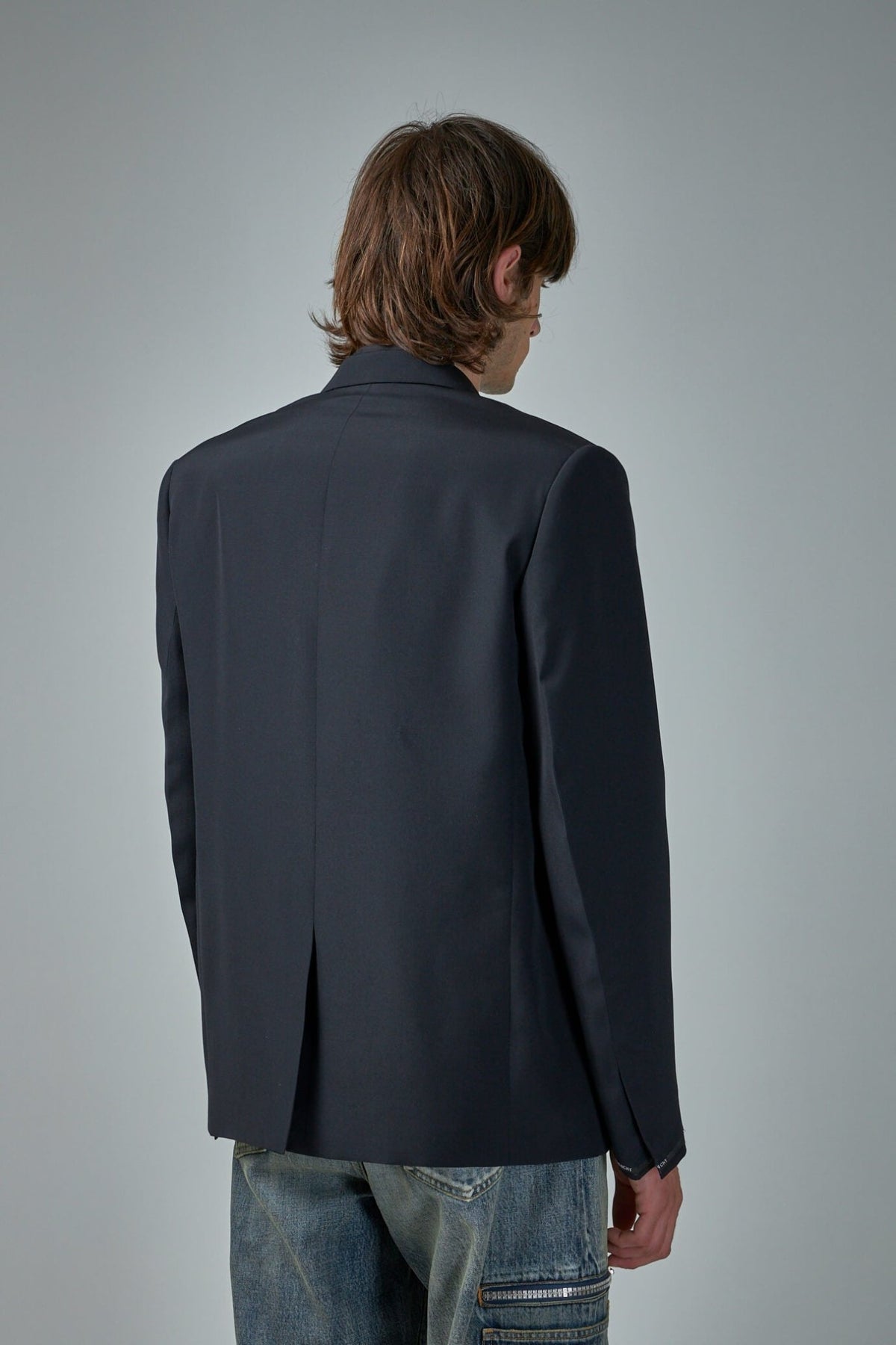 Side profile of Givenchy blazer highlighting the tailored silhouette and construction