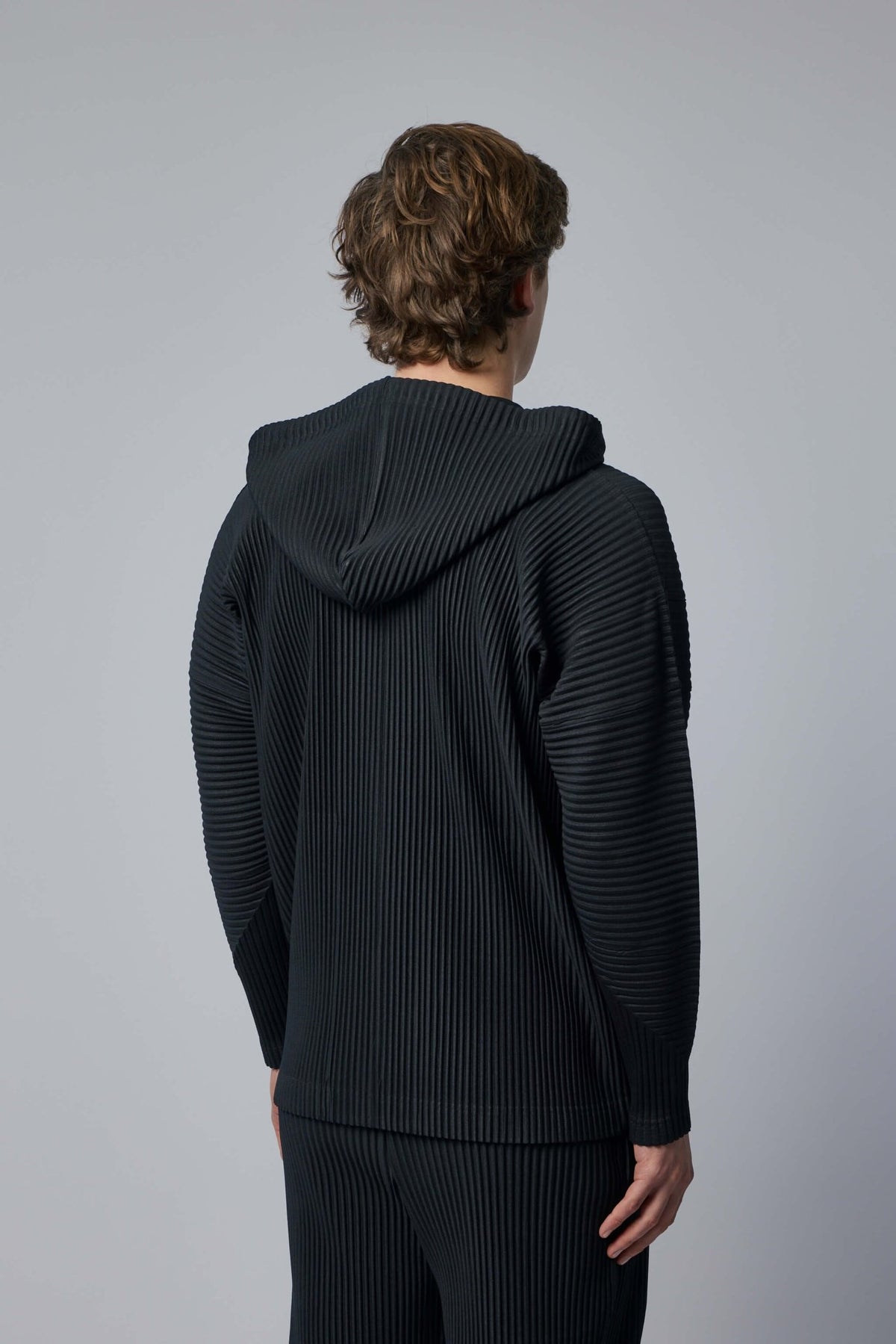 Back view of Issey Miyake pleated hoodie design
