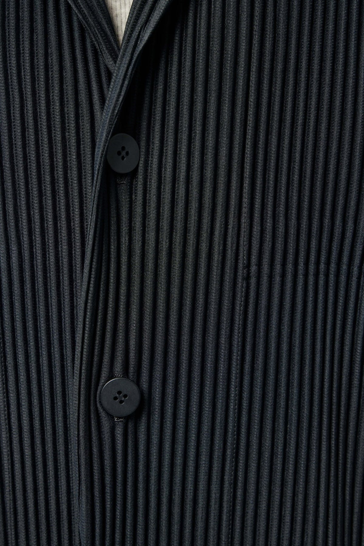 Side view showing structured silhouette of pleated polyester blazer
