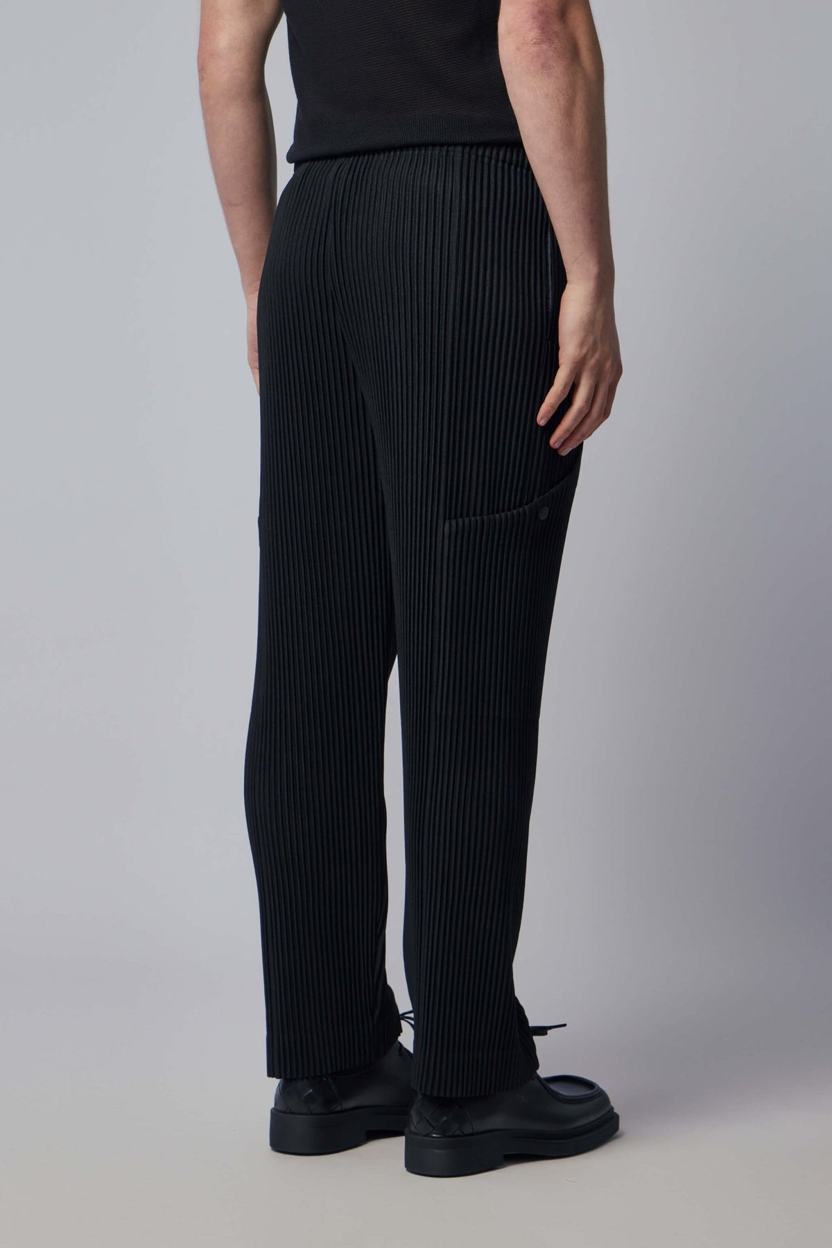 Model wearing black ribbed cargo pants with contemporary styling