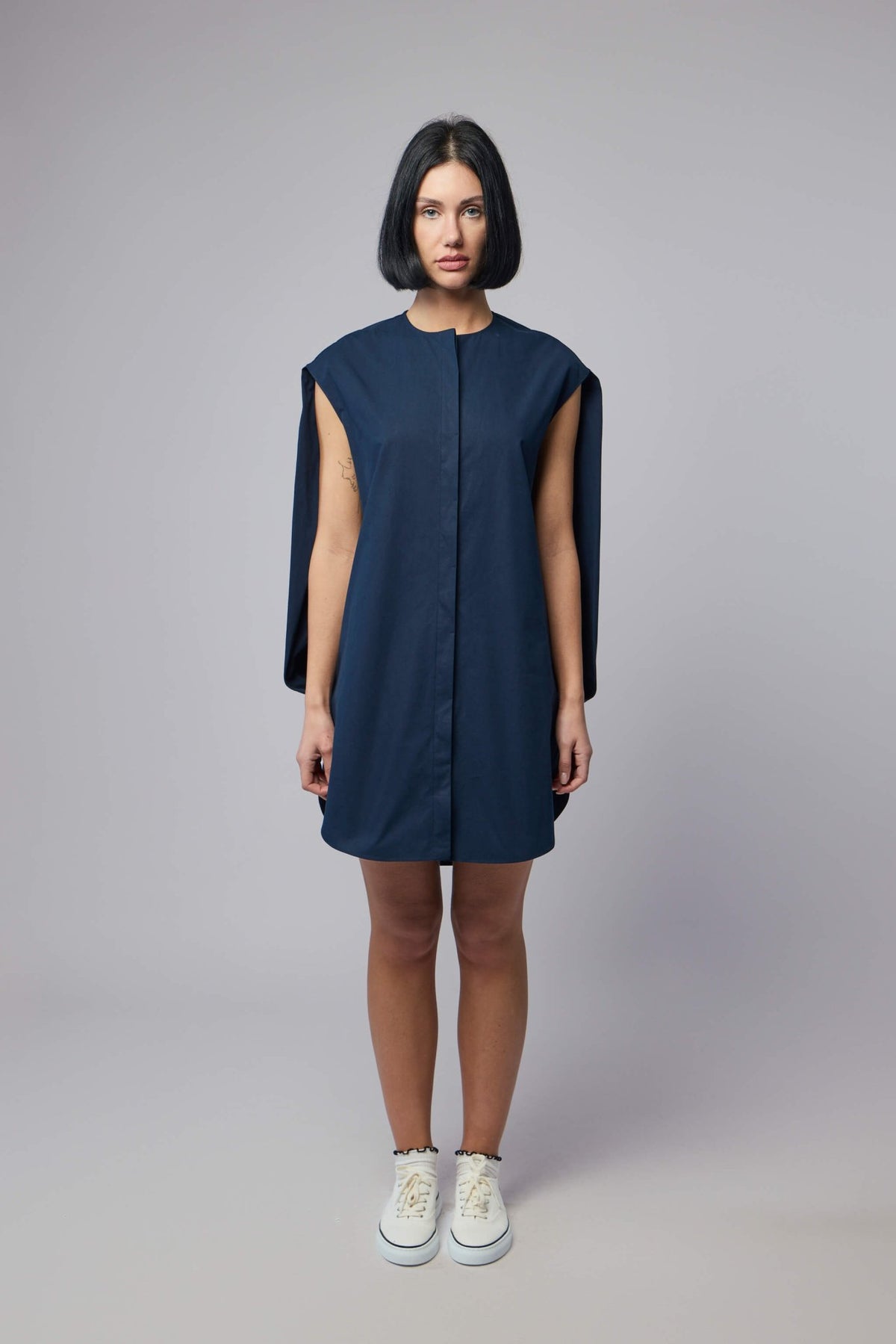 Close-up detail of cape sleeve construction on navy cotton mini dress