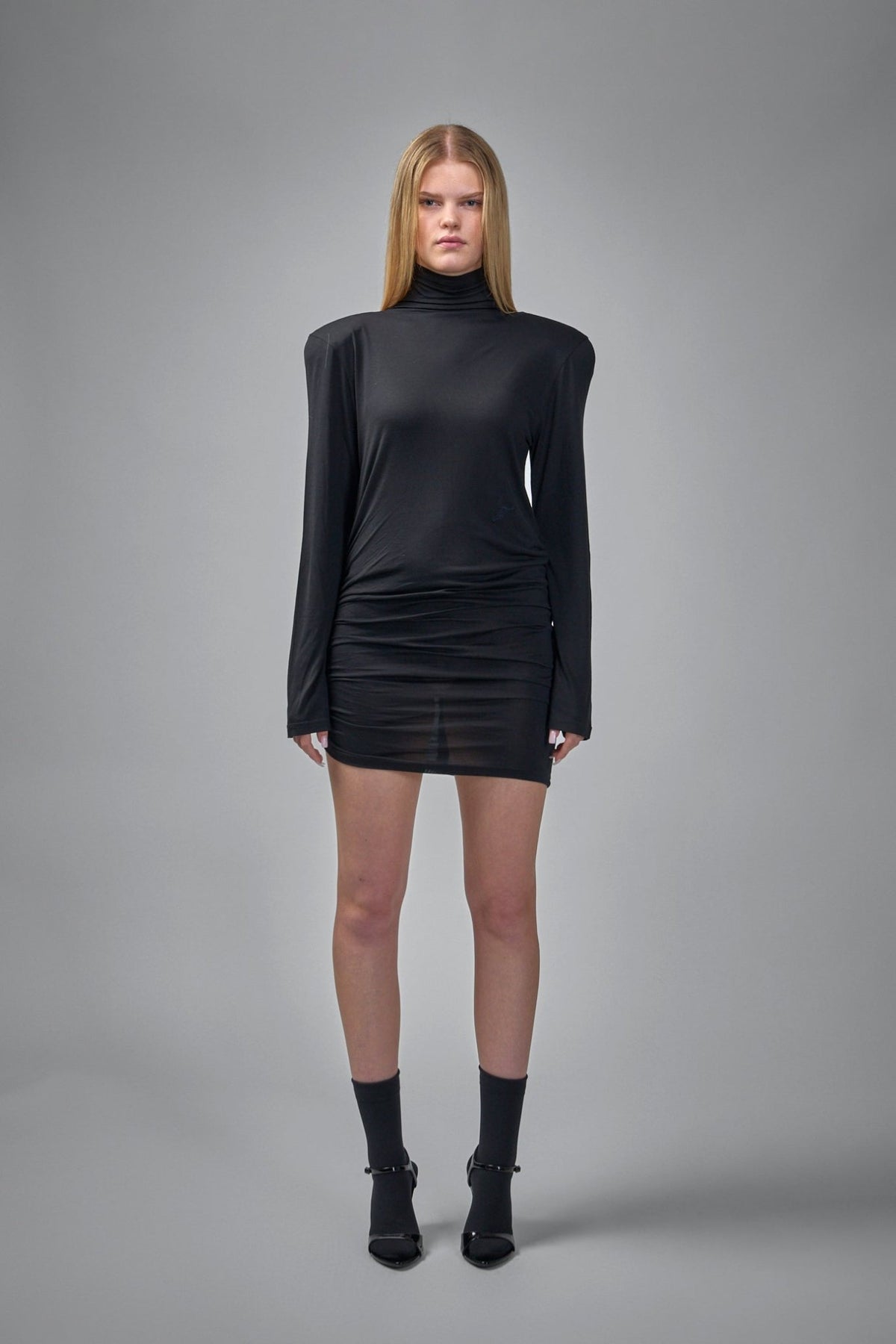 Close-up view of Jacquemus dress showing ruched skirt detailing and asymmetrical hem