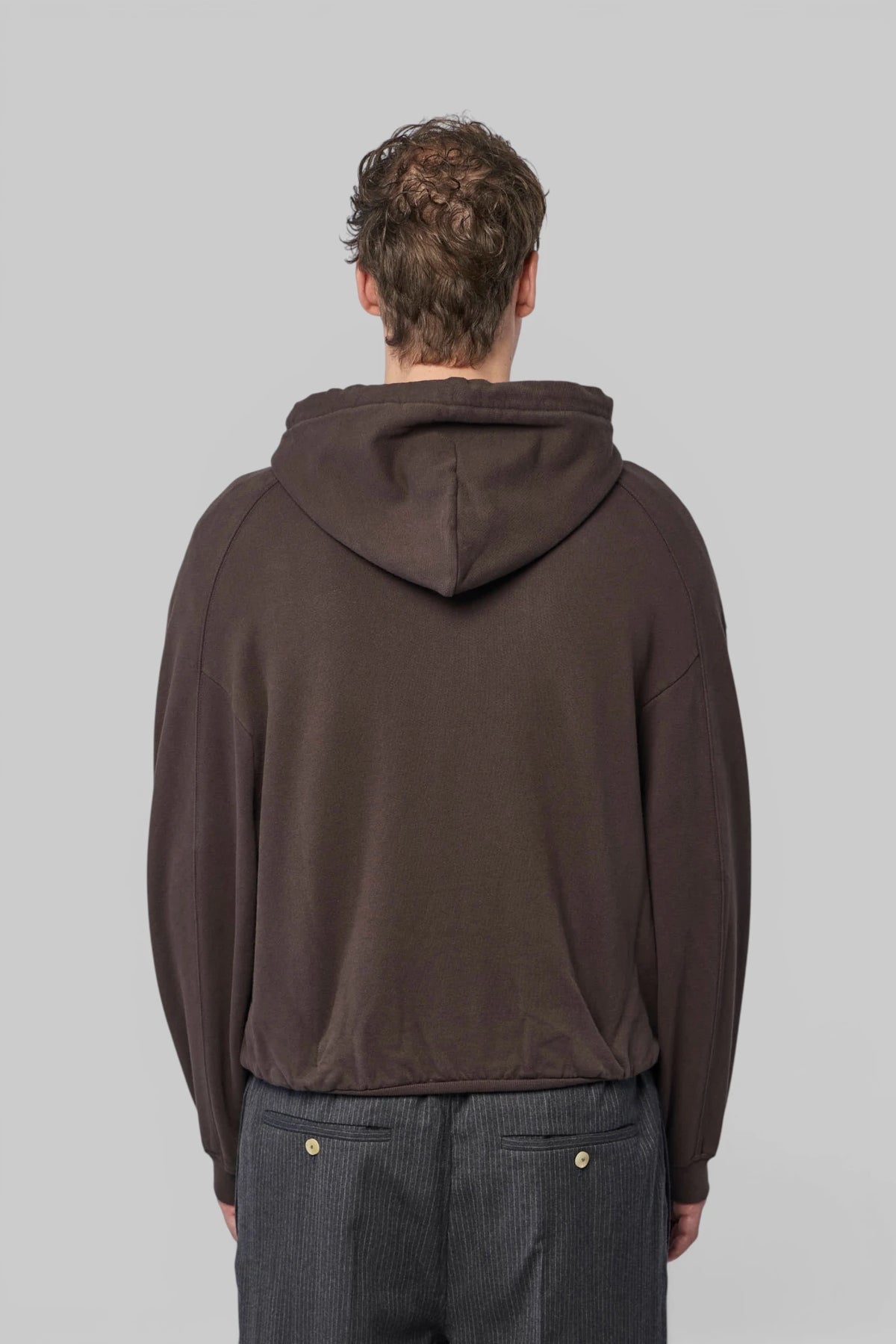 Jacquemus brown hoodie styled with tailored trousers