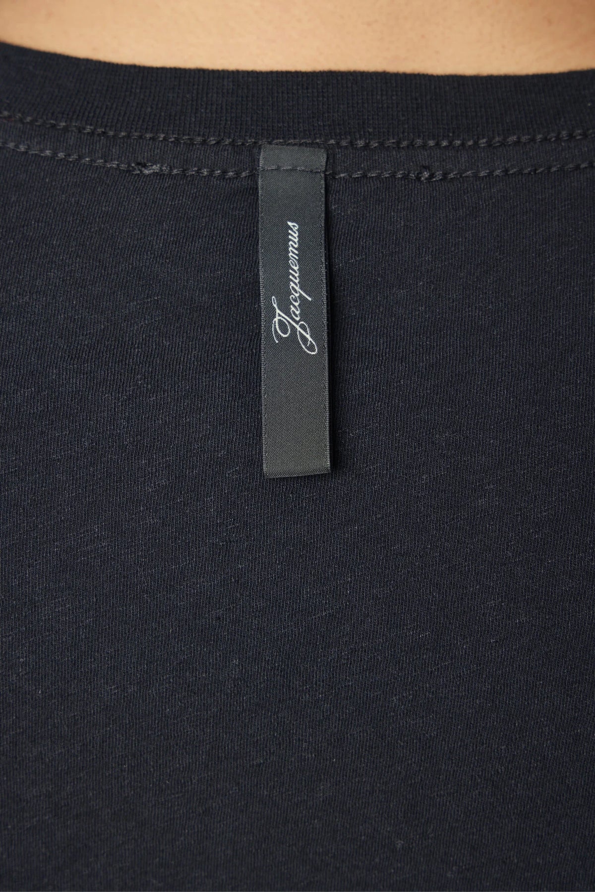 Jacquemus sweatshirt folded, highlighting deep black colorway and texture