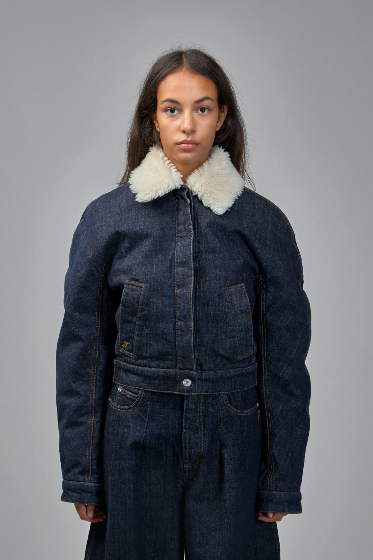 Close-up of cream shearling collar detail on Jacquemus denim jacket