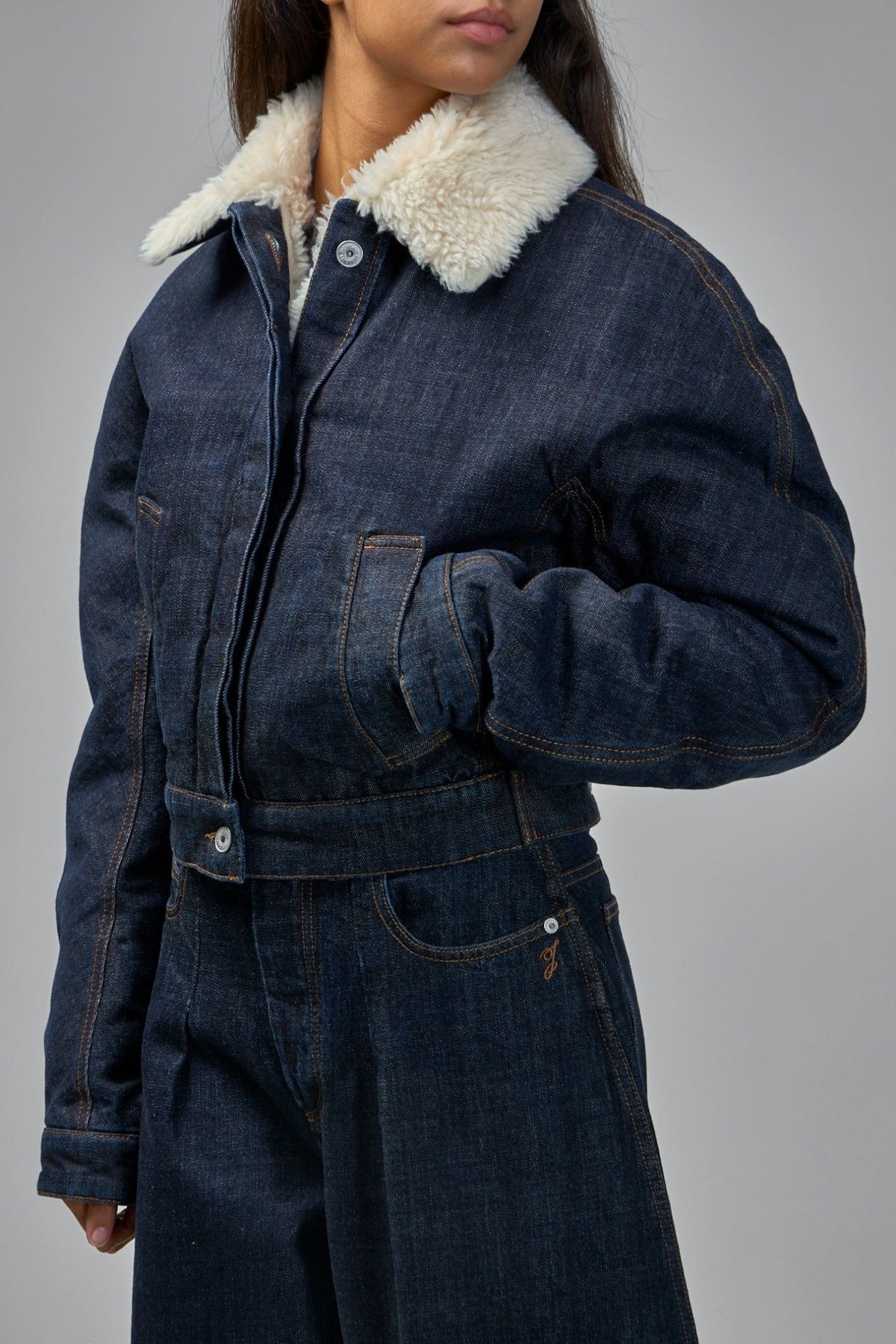 Detail shot of contrast topstitching and metal buttons on denim jacket