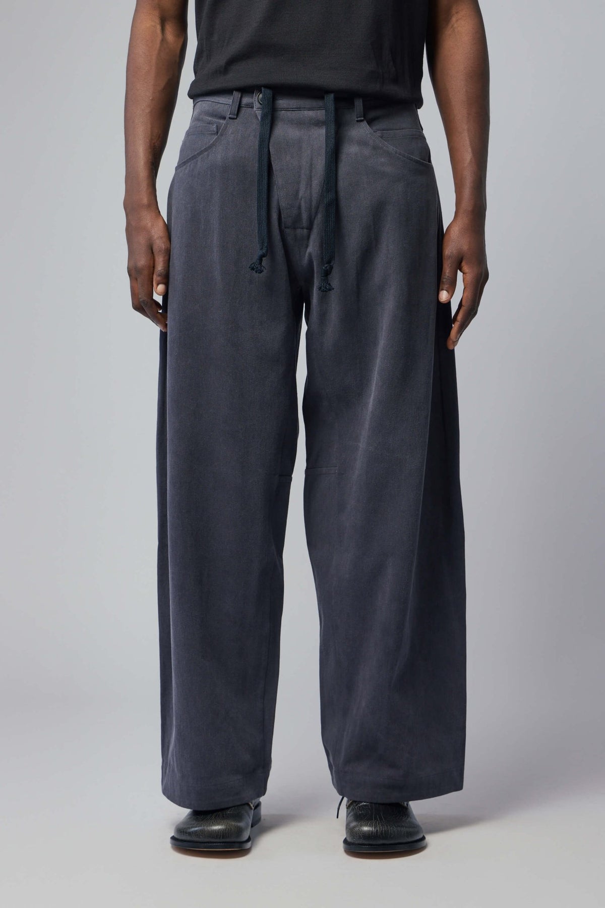 Side view of Trousers#90 showing relaxed wide-leg silhouette and pocket details