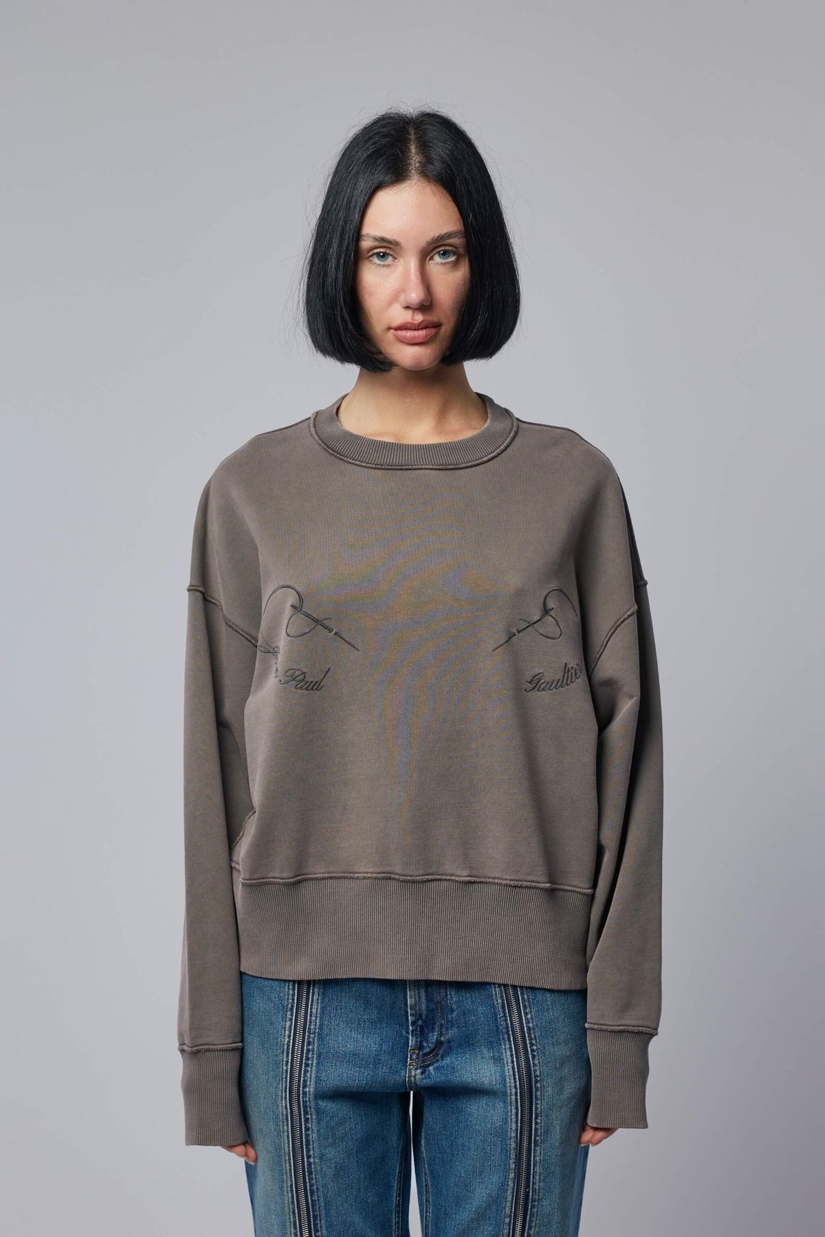 Close-up of Jean Paul Gaultier embroidered needles graphic detail on sweatshirt