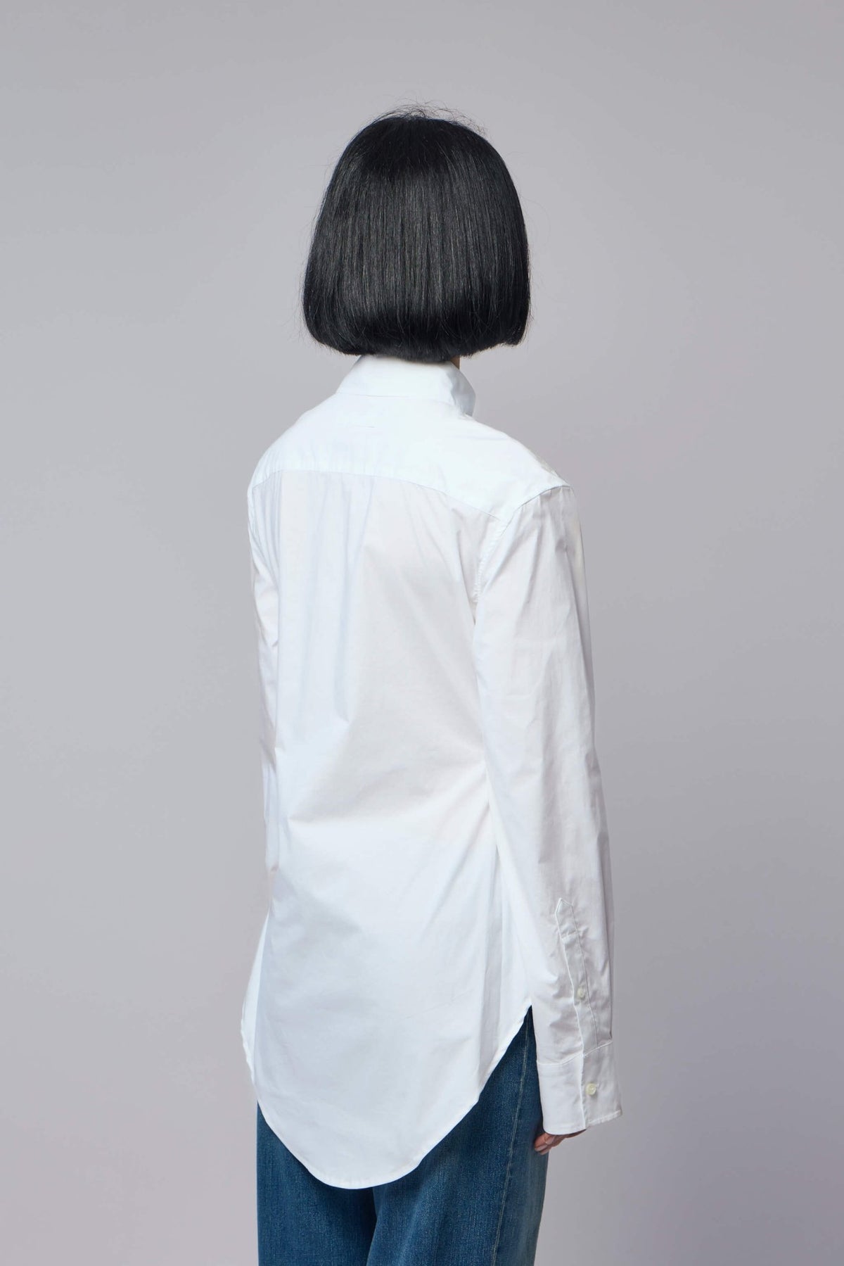 Detail shot of pointed collar and cuffed sleeves on printed shirt