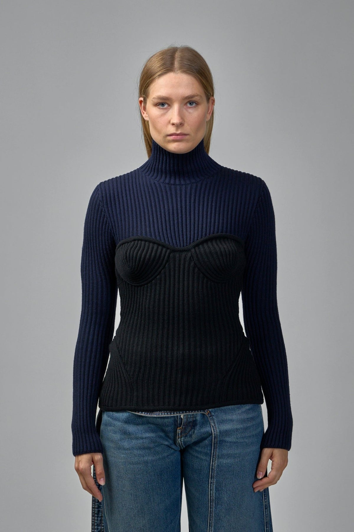 Close-up of ribbed merino wool texture and contrasting bustier panel on luxury sweater