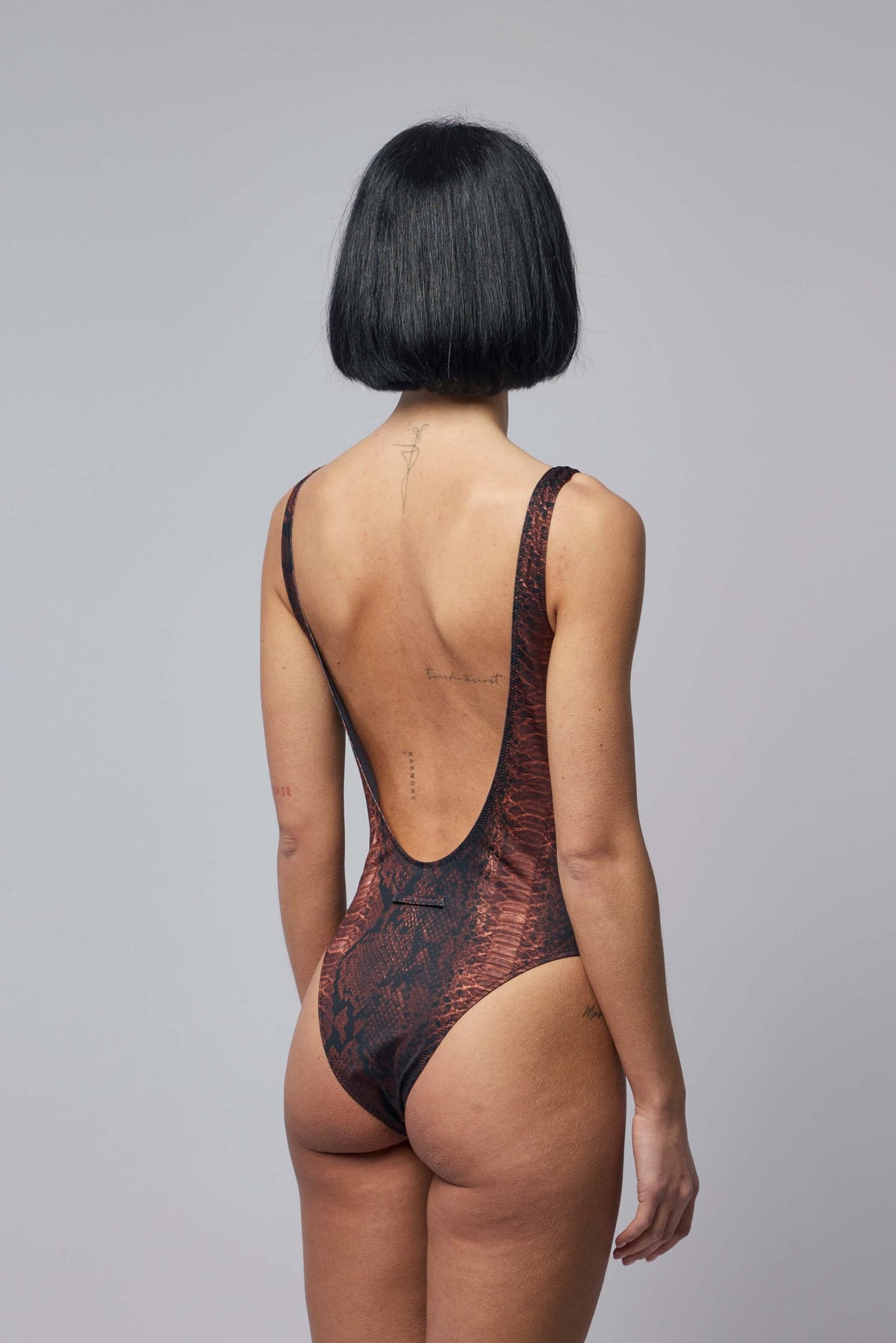 Model wearing Jean Paul Gaultier python print one-piece swimsuit