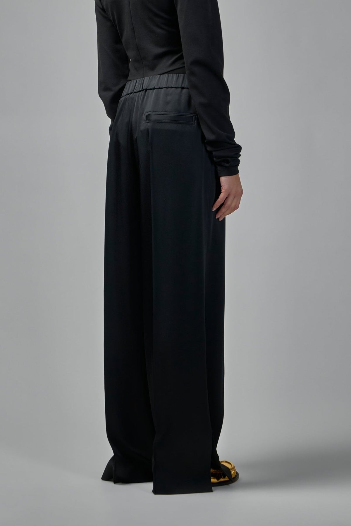Close-up detail of premium satin fabric texture on wide-leg pants