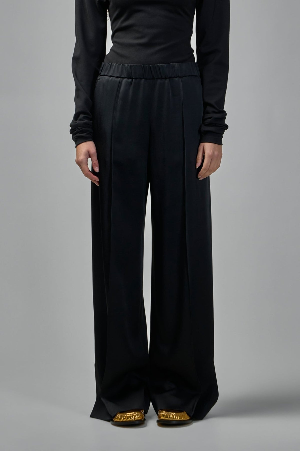 Model wearing Jil Sander Envers satin trousers showing relaxed fit
