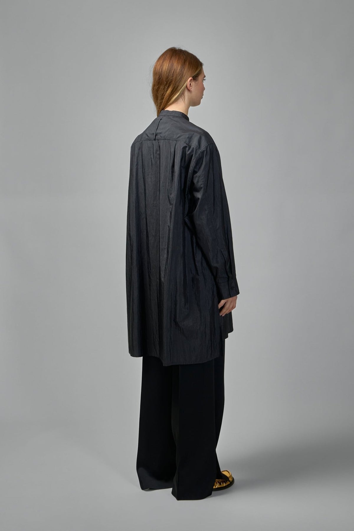 Side view of loose-fitting black Jil Sander blouse with long sleeves