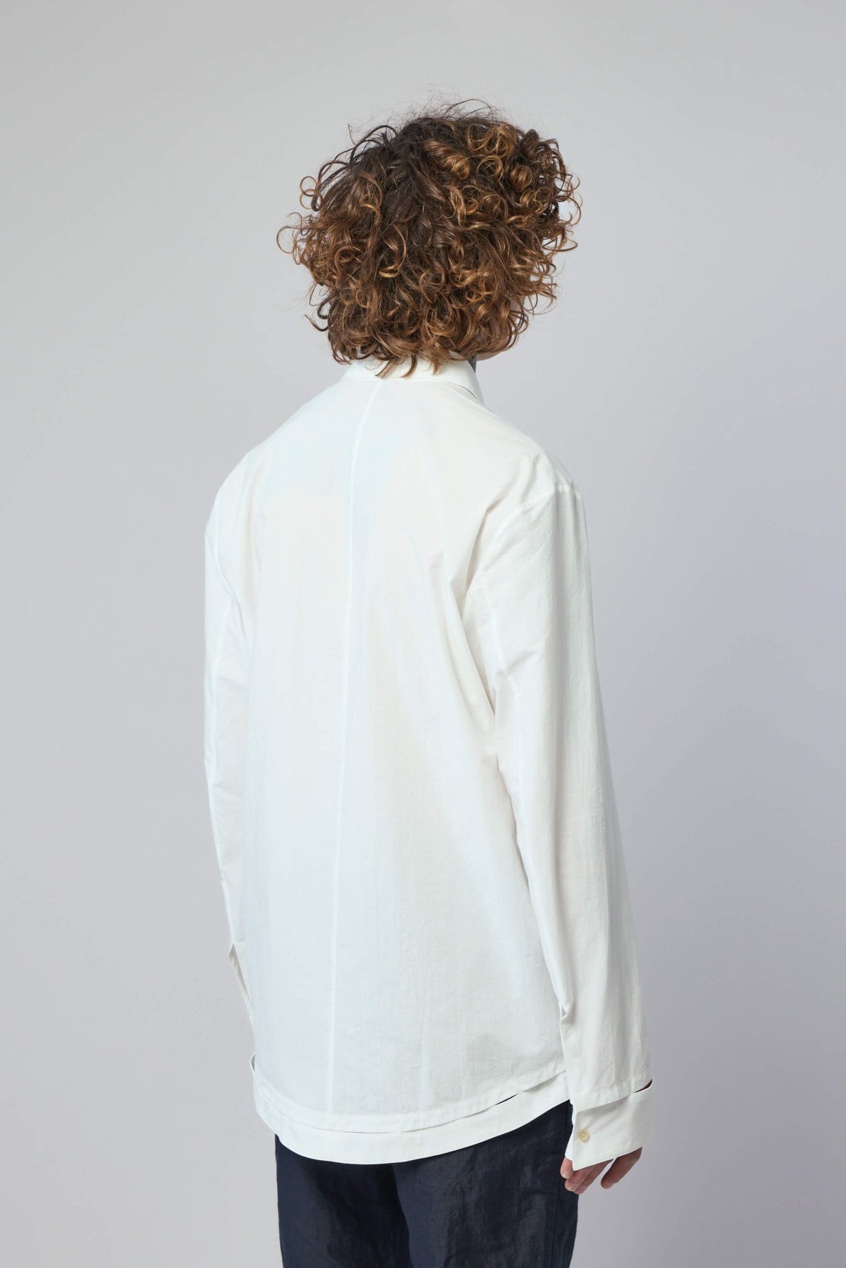 Side profile of K'ang hand-stitched shirt demonstrating tailored fit