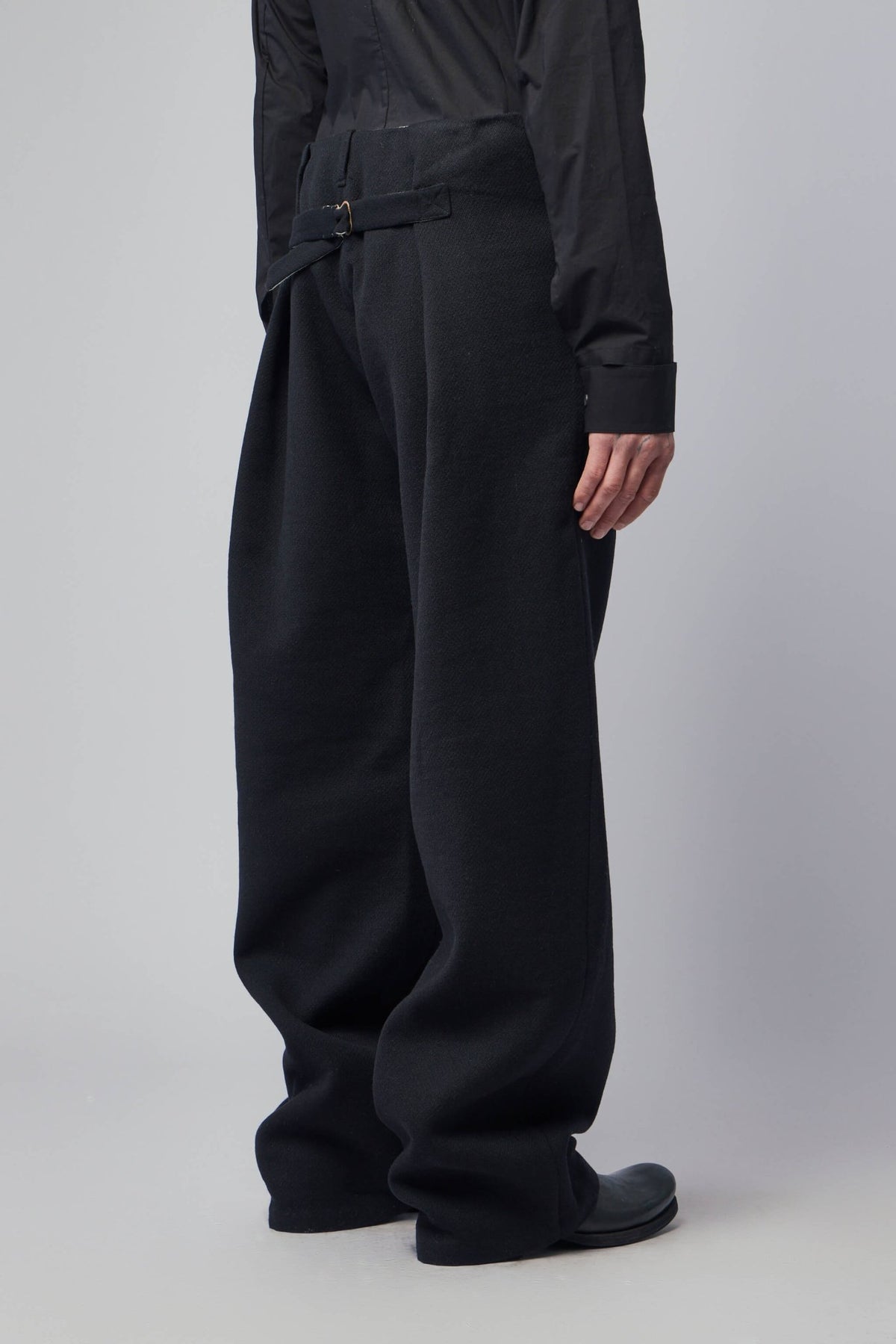 Side view of K'ANG unisex trousers highlighting wide-leg cut