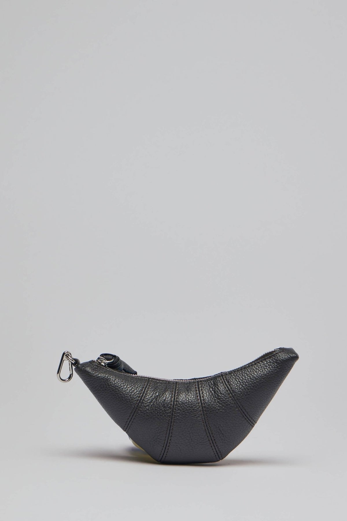 Side profile showing crescent-shaped design and stitched panel accents