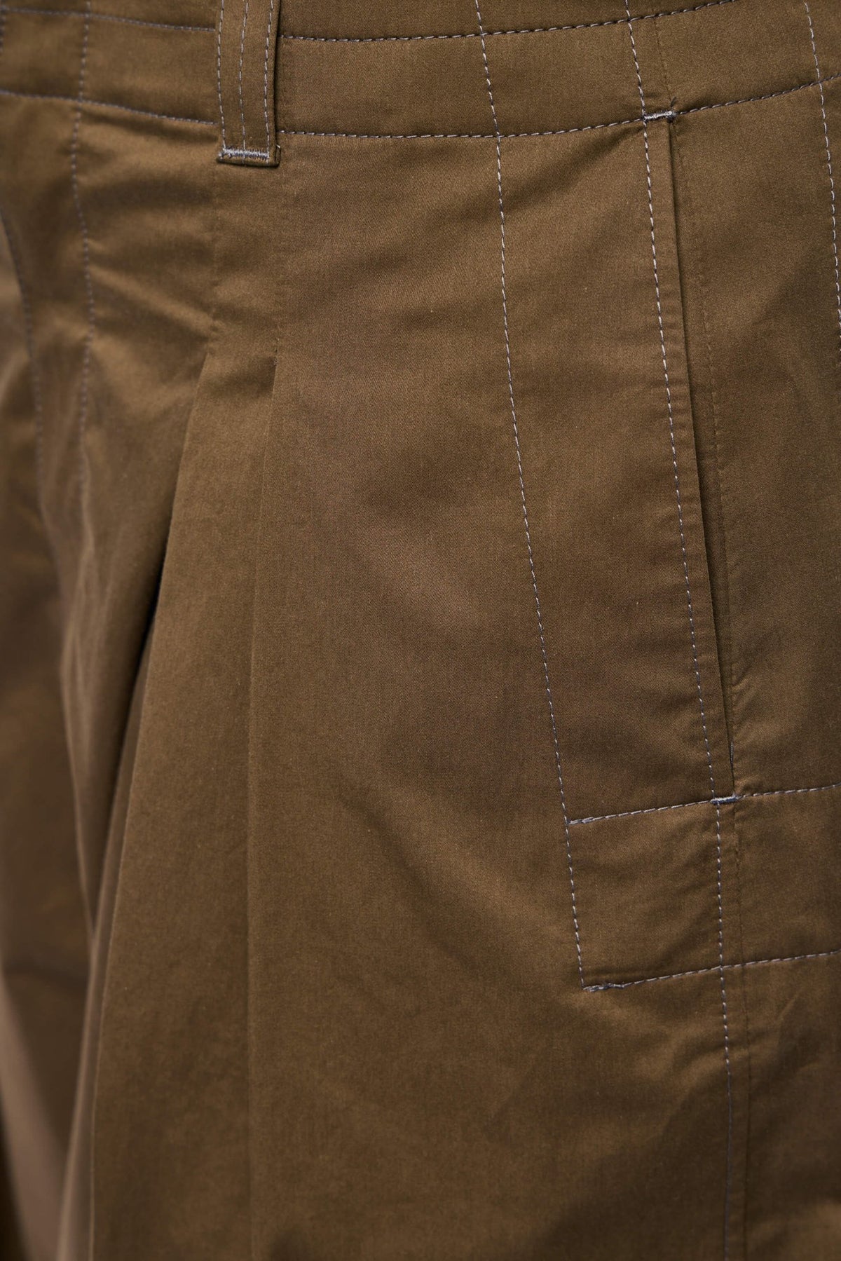 Side view showing the relaxed volume silhouette of Lemaire cargo pants
