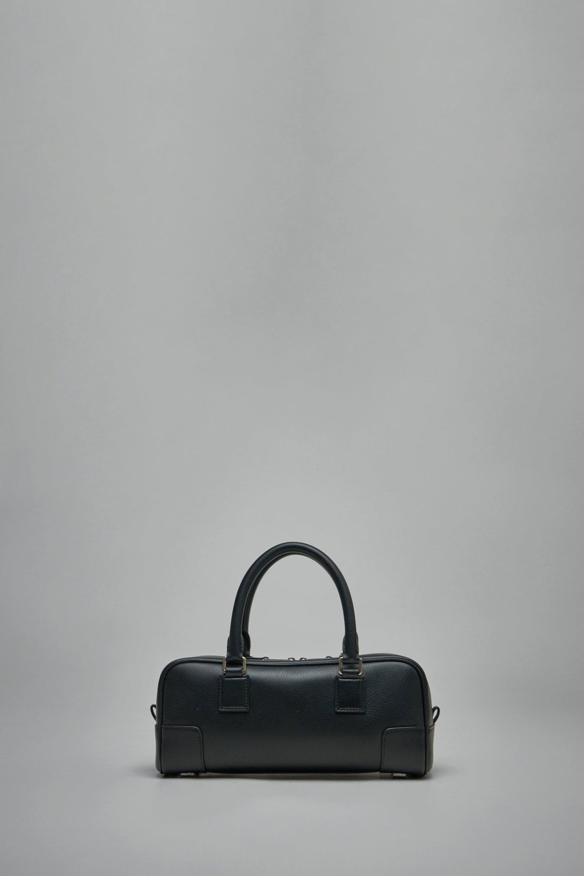 Lifestyle shot of woman carrying Loewe Amazona Cropped bag in urban setting