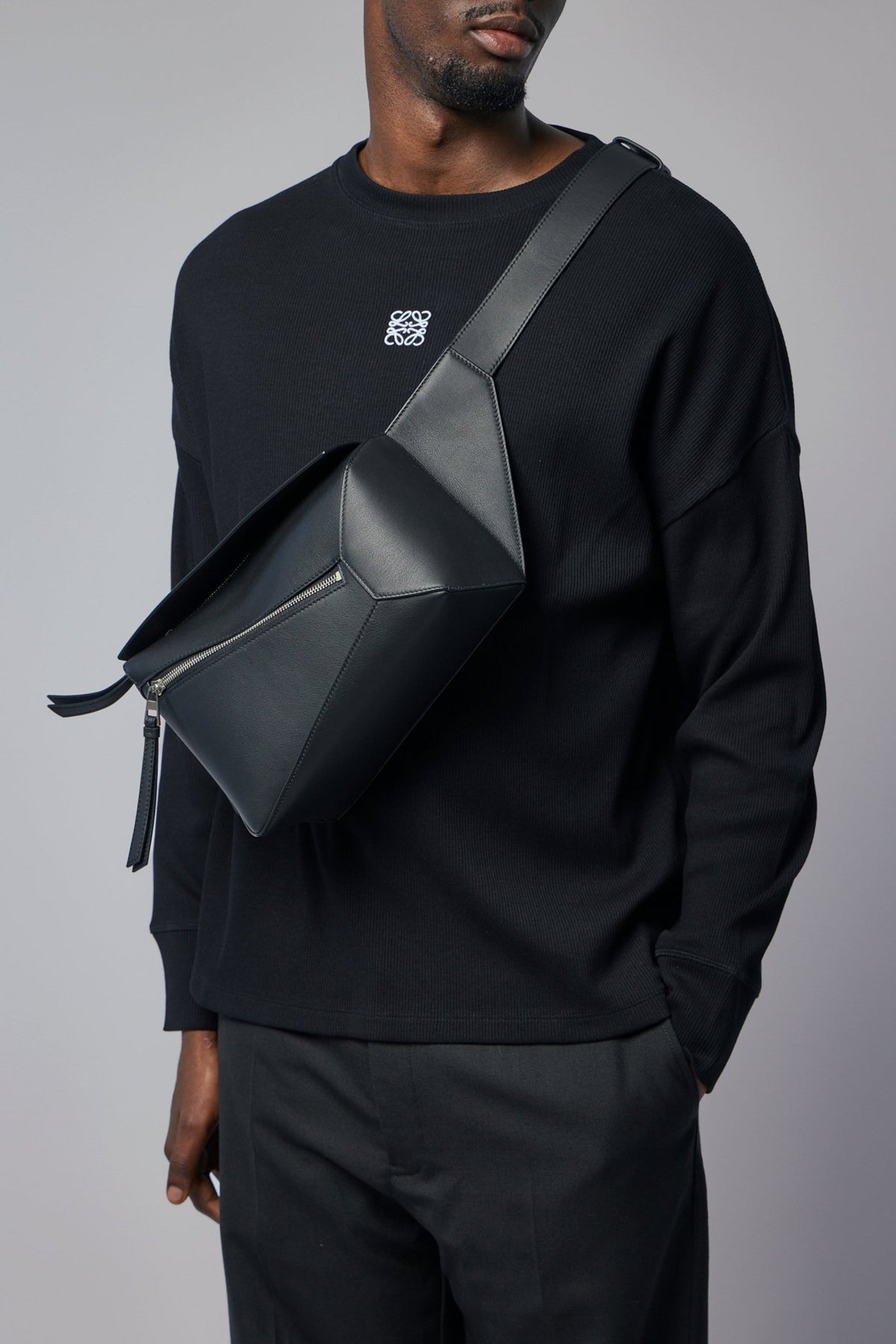 Side view of Loewe crossbody bag displaying adjustable strap and structured silhouette