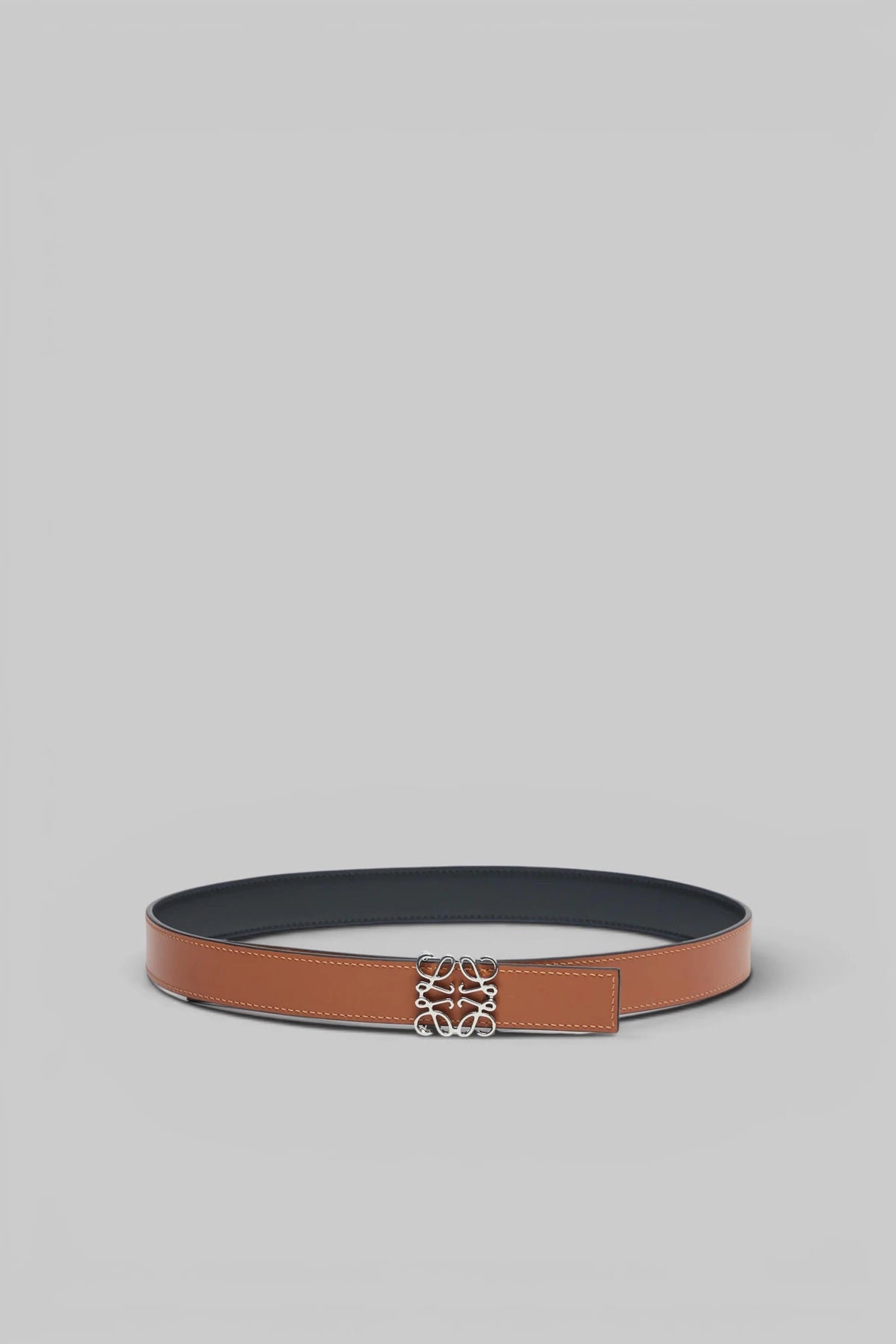 Close-up of Loewe anagram belt buckle detail in polished metal