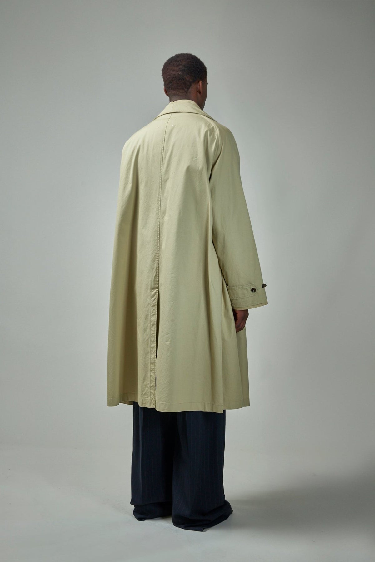 Contemporary layered trench coat styling detail view