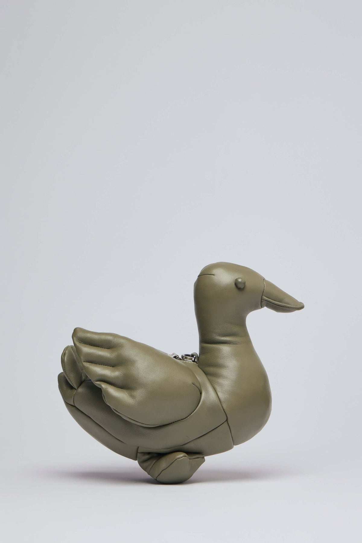Side view showing adjustable shoulder strap and unique duck-inspired silhouette