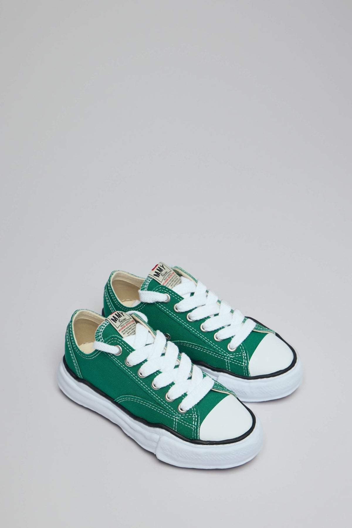 Side view of green canvas Peterson sneakers showing lace-up design and round toe