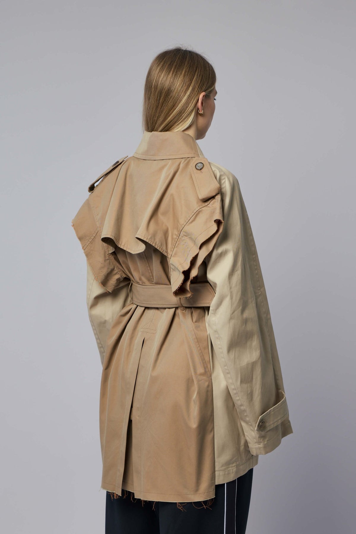 Detail shot of button closure and belted waist on beige coat