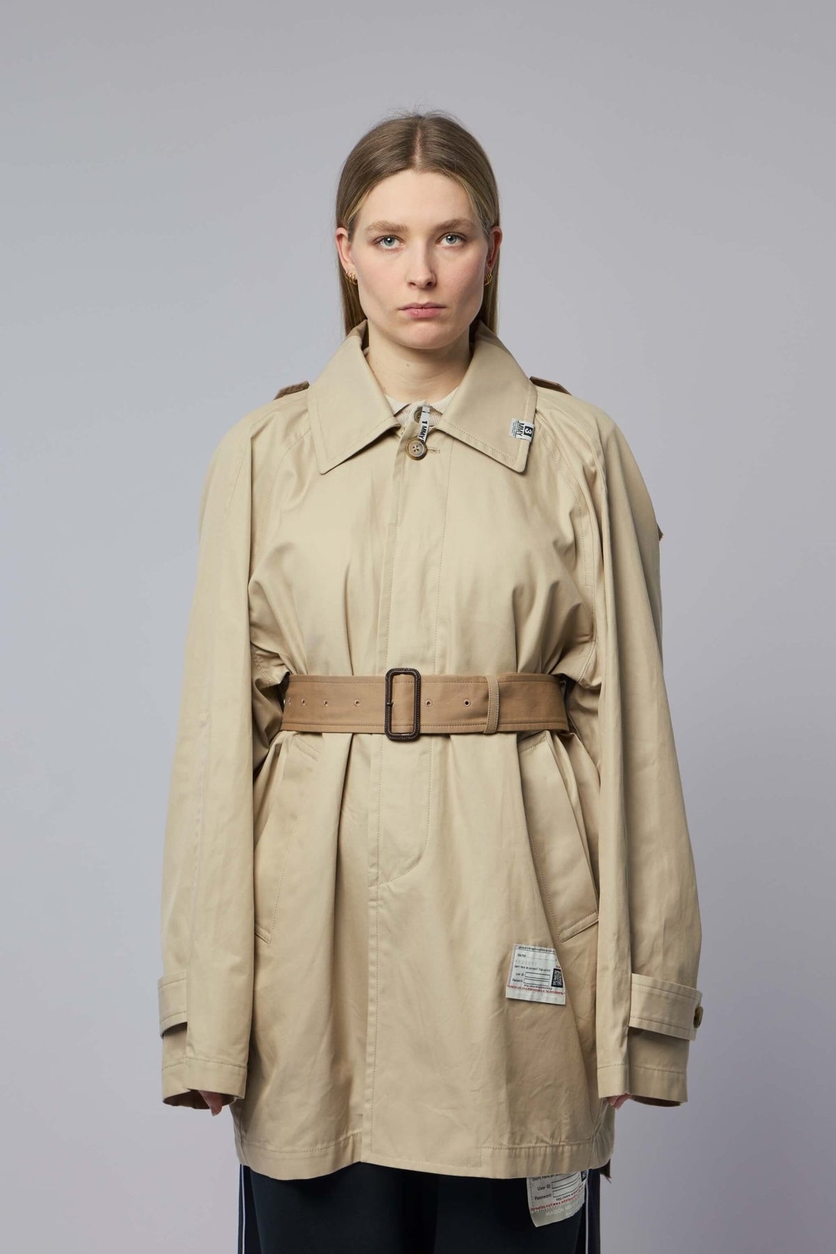 Close-up of beige cotton coat showing shoulder epaulettes and collar details