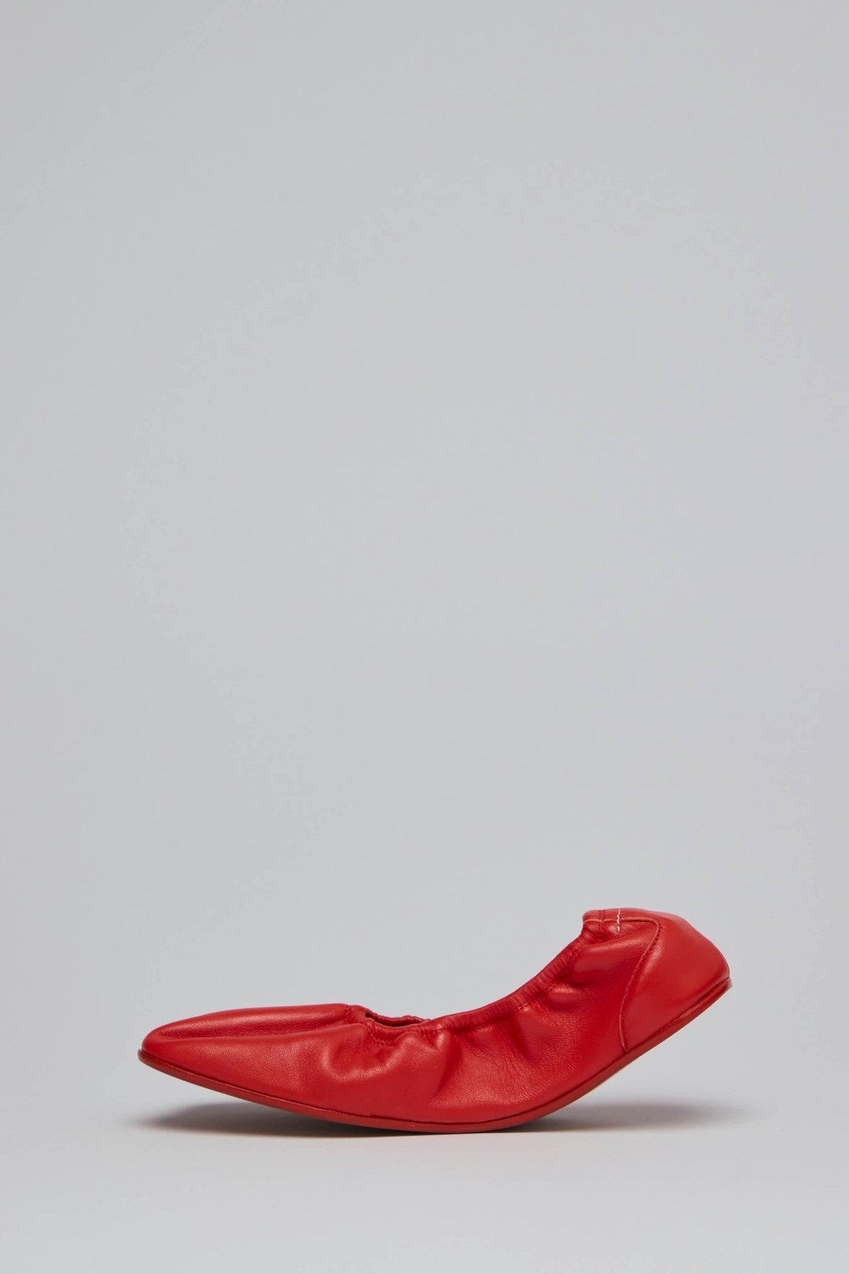 Side view of red MM6 Margiela flat showcasing minimalist slip-on design