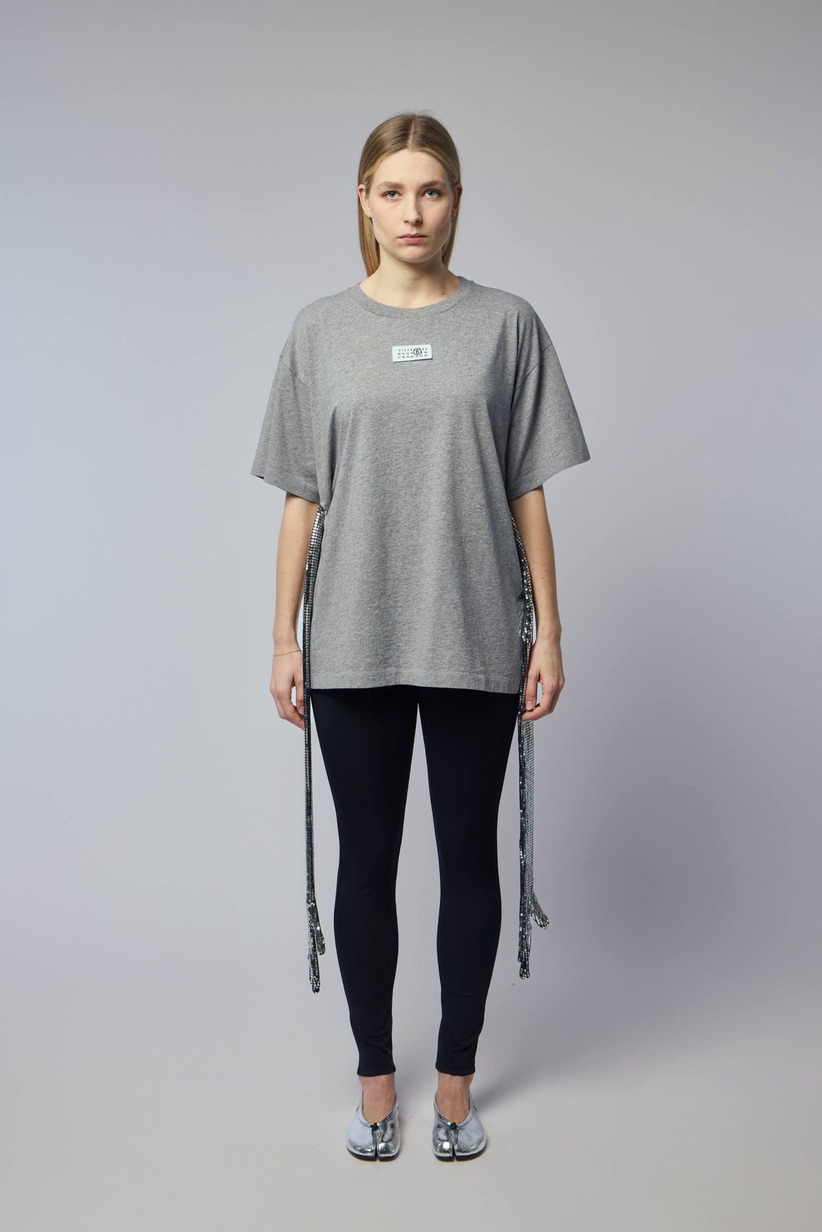 Close-up of decorative sequin strips hanging from MM6 Margiela t-shirt sides