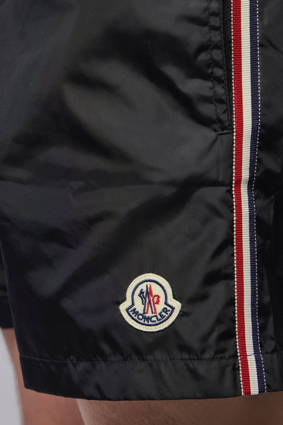 Full length view of black Moncler shorts with smooth fabric texture