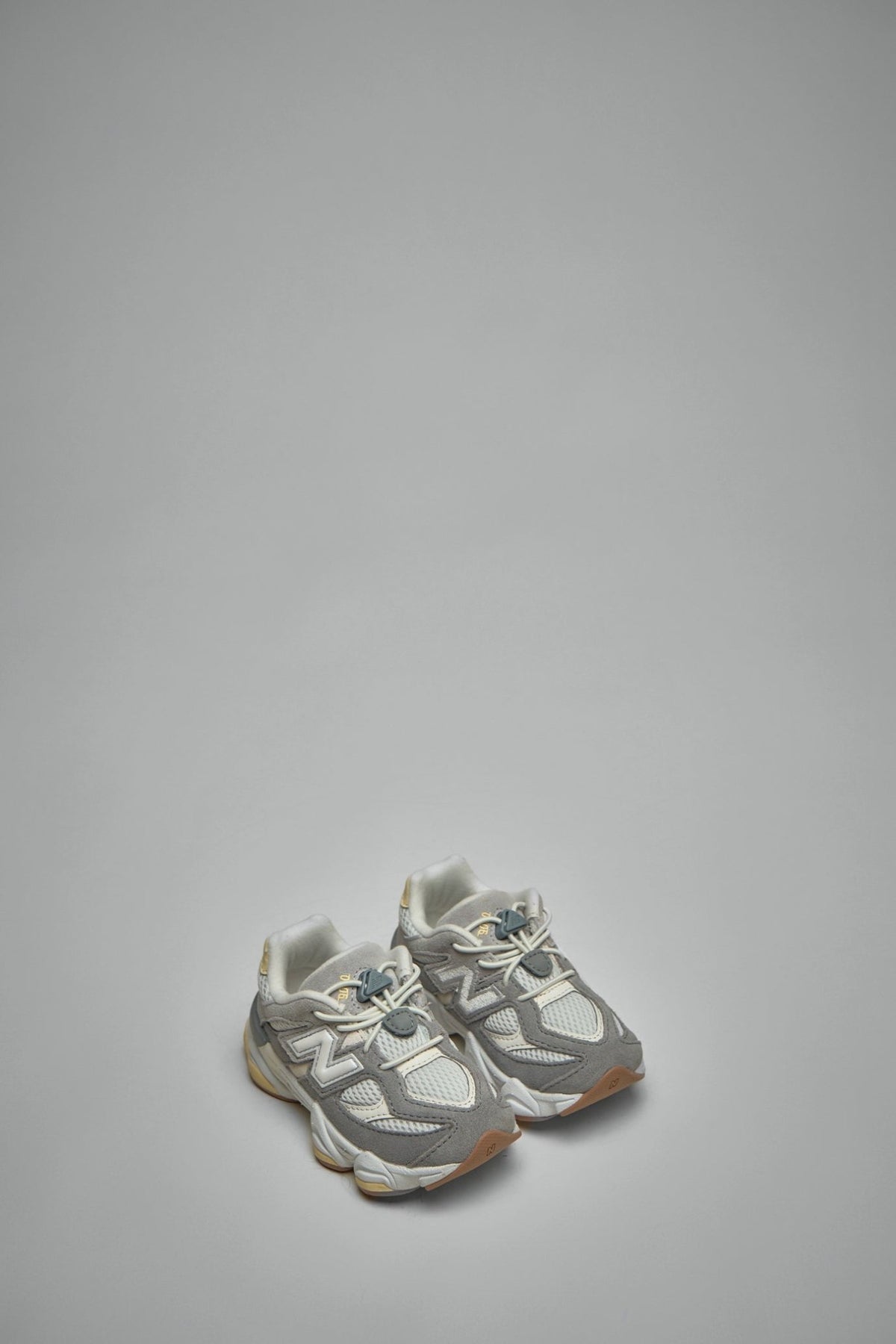 Side view of New Balance 9060 sneakers showing suede overlays and brand logo detail