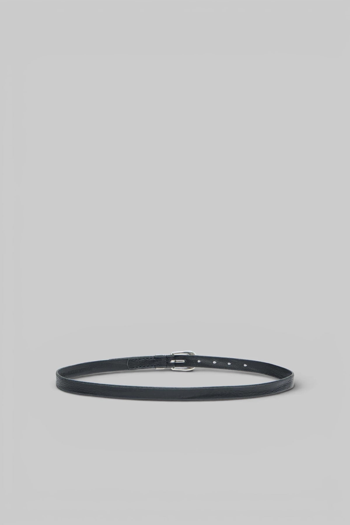 Close-up of polished silver buckle on Our Legacy belt