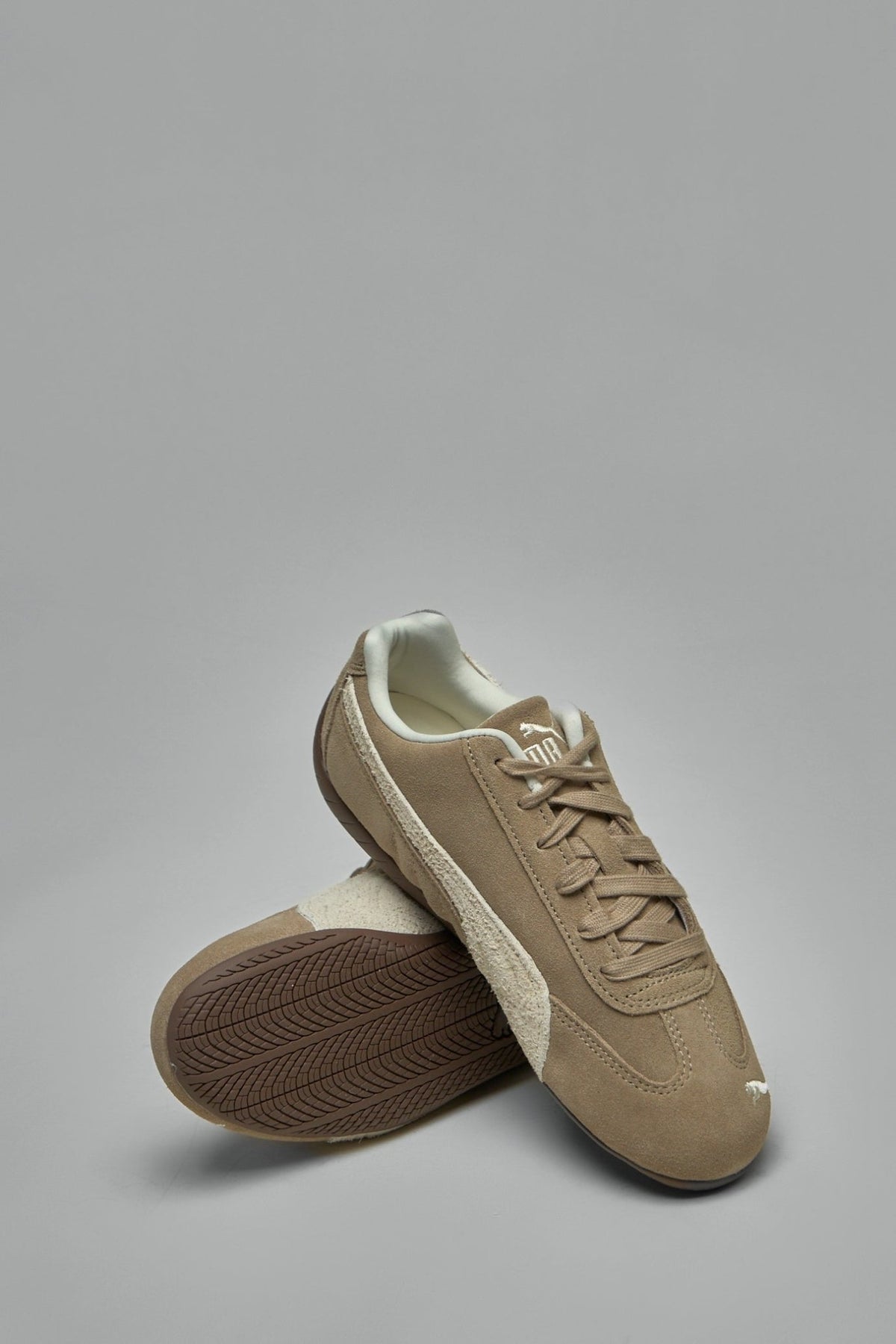 Full product shot of brown Puma low top sneakers
