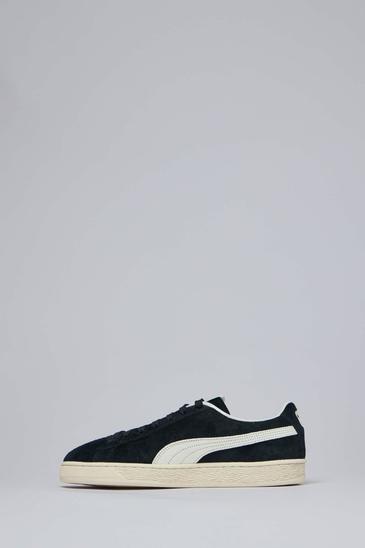 Detail shot of Puma sneaker showing gold branding and construction