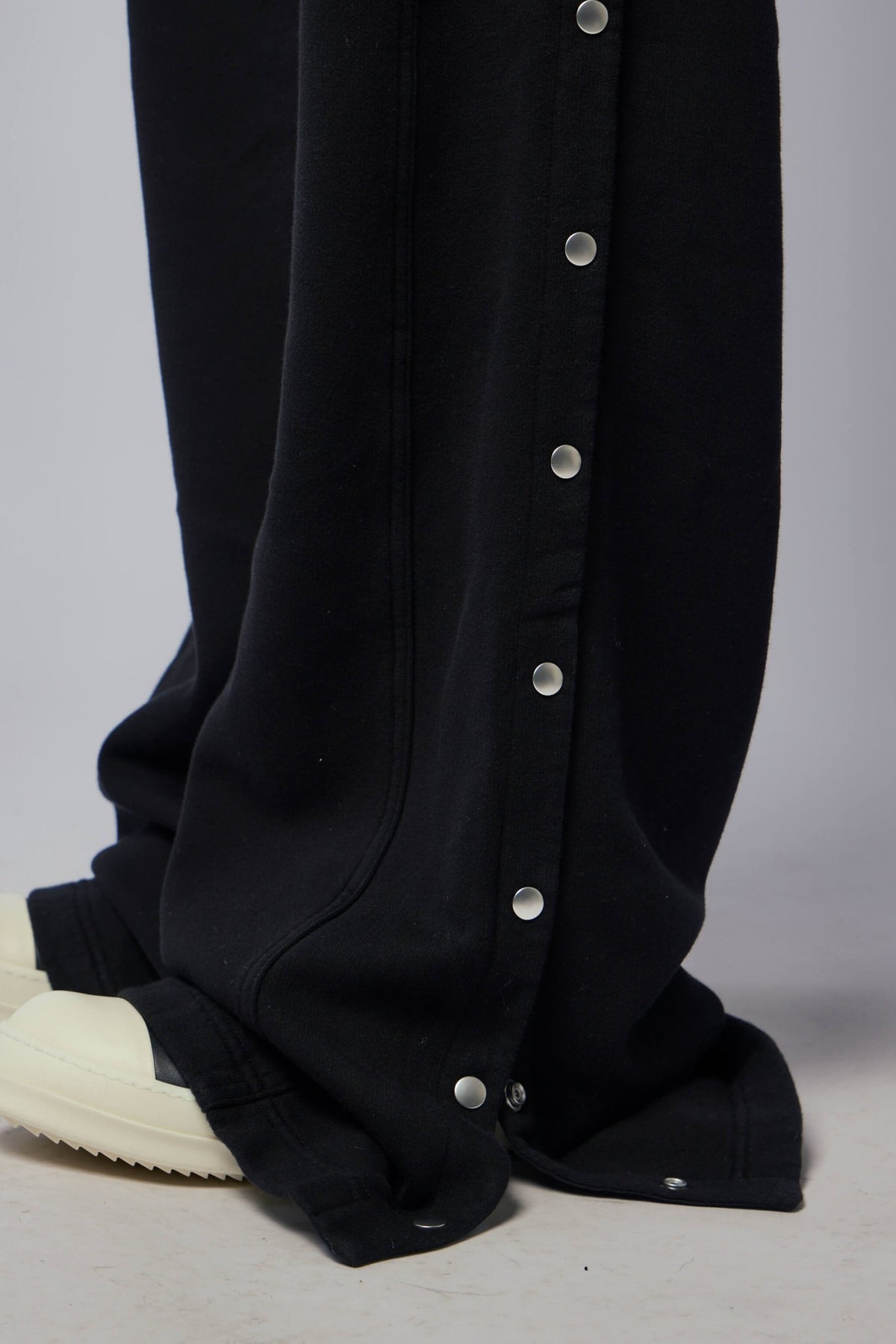 Detail shot of side snap adjustments on DRKSHDW pants