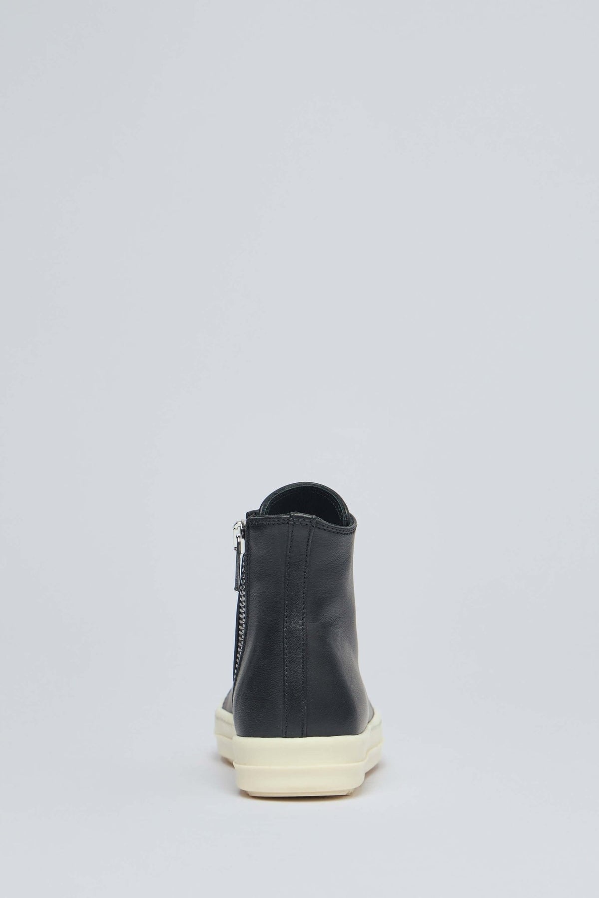 Front view of Rick Owens high top sneakers displaying circular eyelets and lacing system