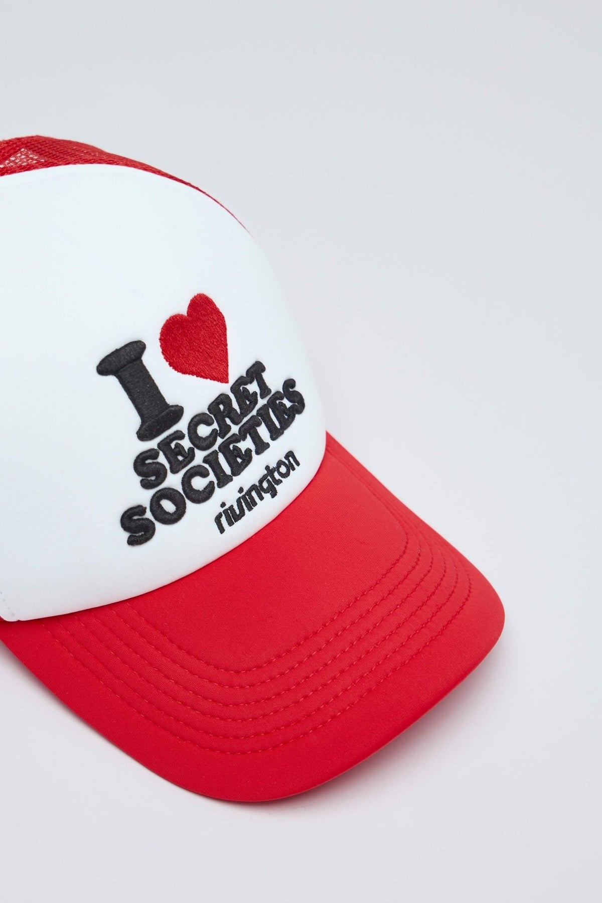 Side view of Secret Societies trucker hat showing mesh panel details