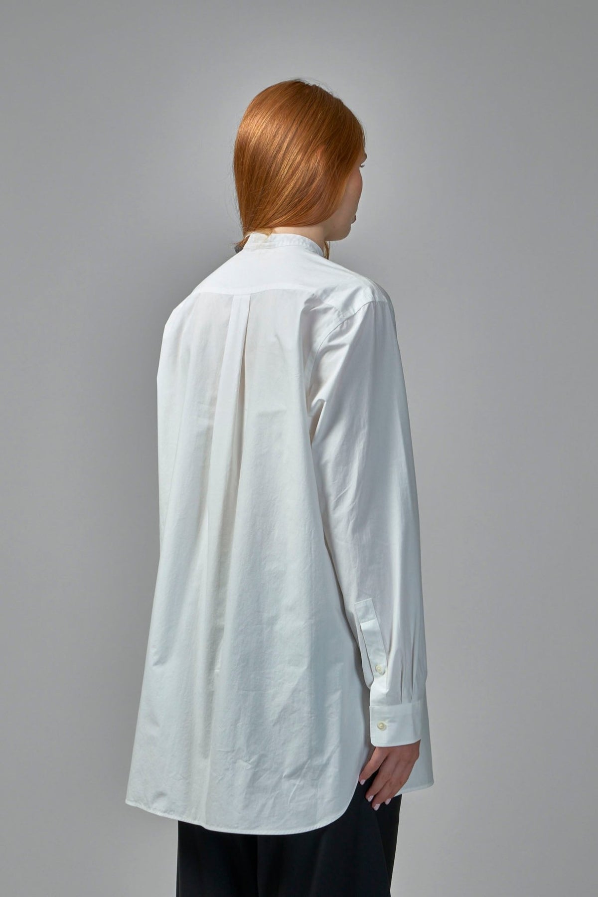 Back view highlighting rounded hem and sophisticated tailoring