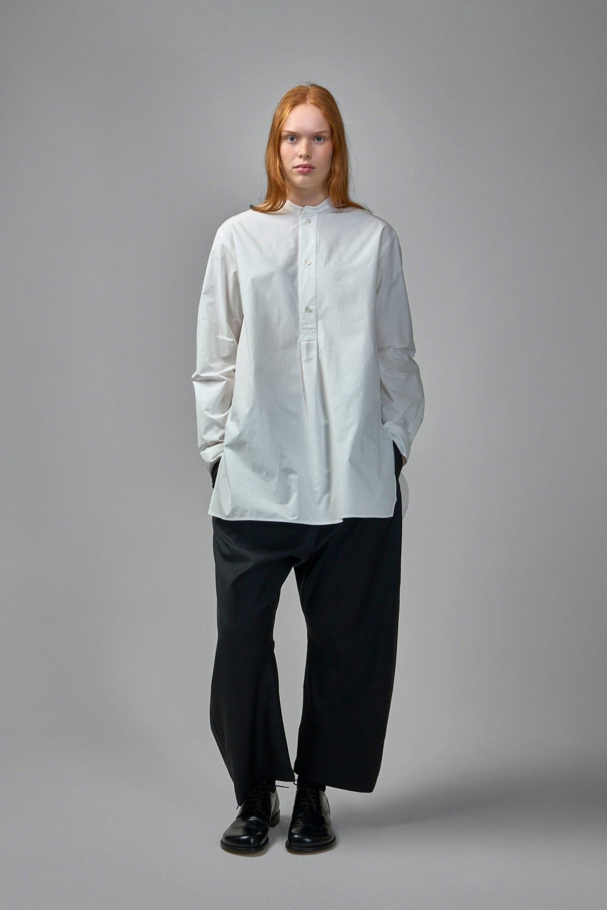 Close-up of mandarin collar and button placket detail on white cotton shirt